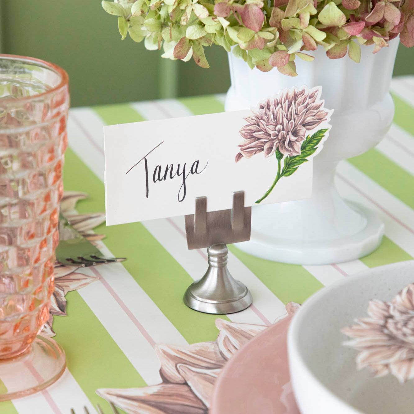 Dahlia Place Card with "Tanya" written in the white space, held up by the Chrome Place Card Holder.