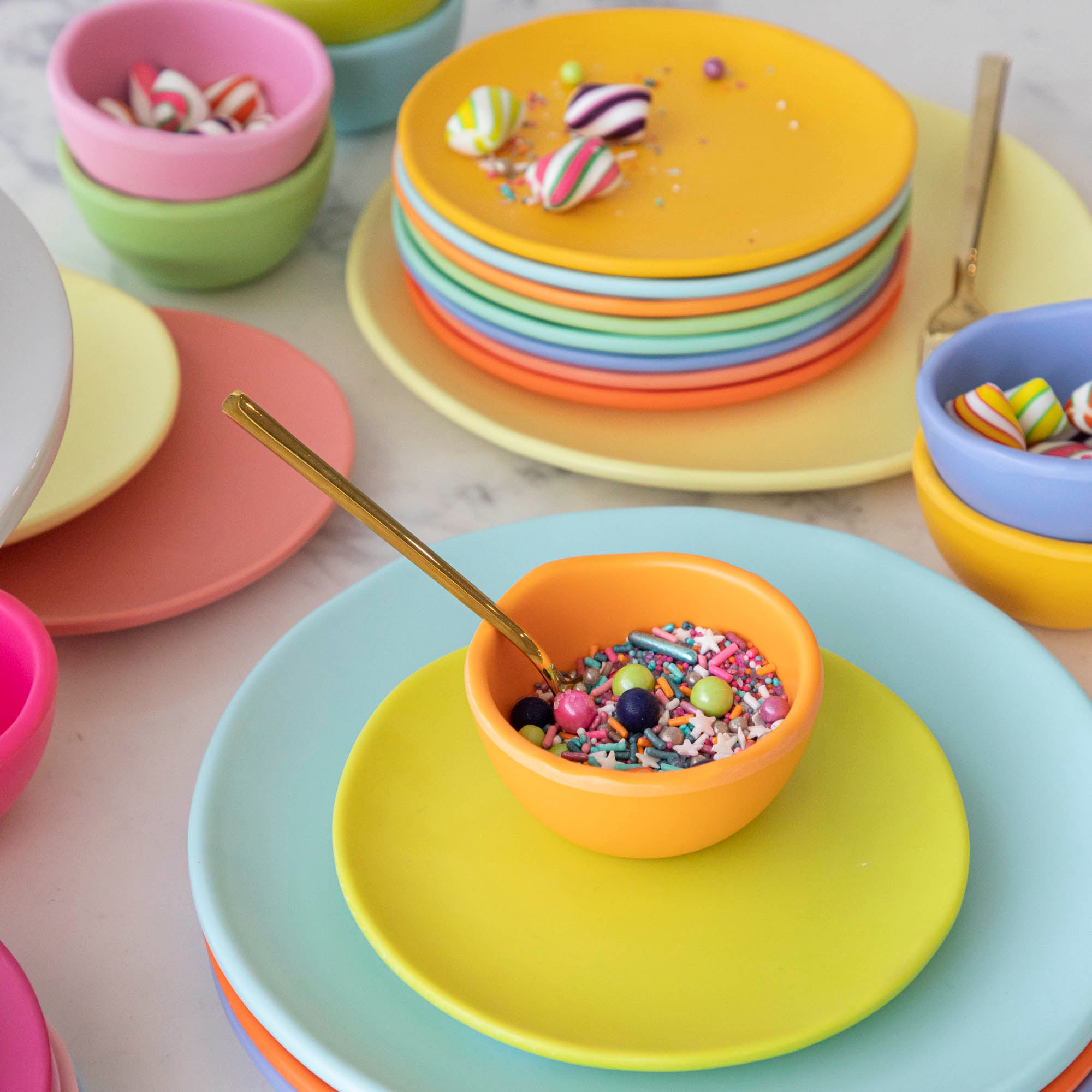 A set of colorful, dishwasher-safe Glitterville Rainbow Melamine Trinket Bowls on a table.