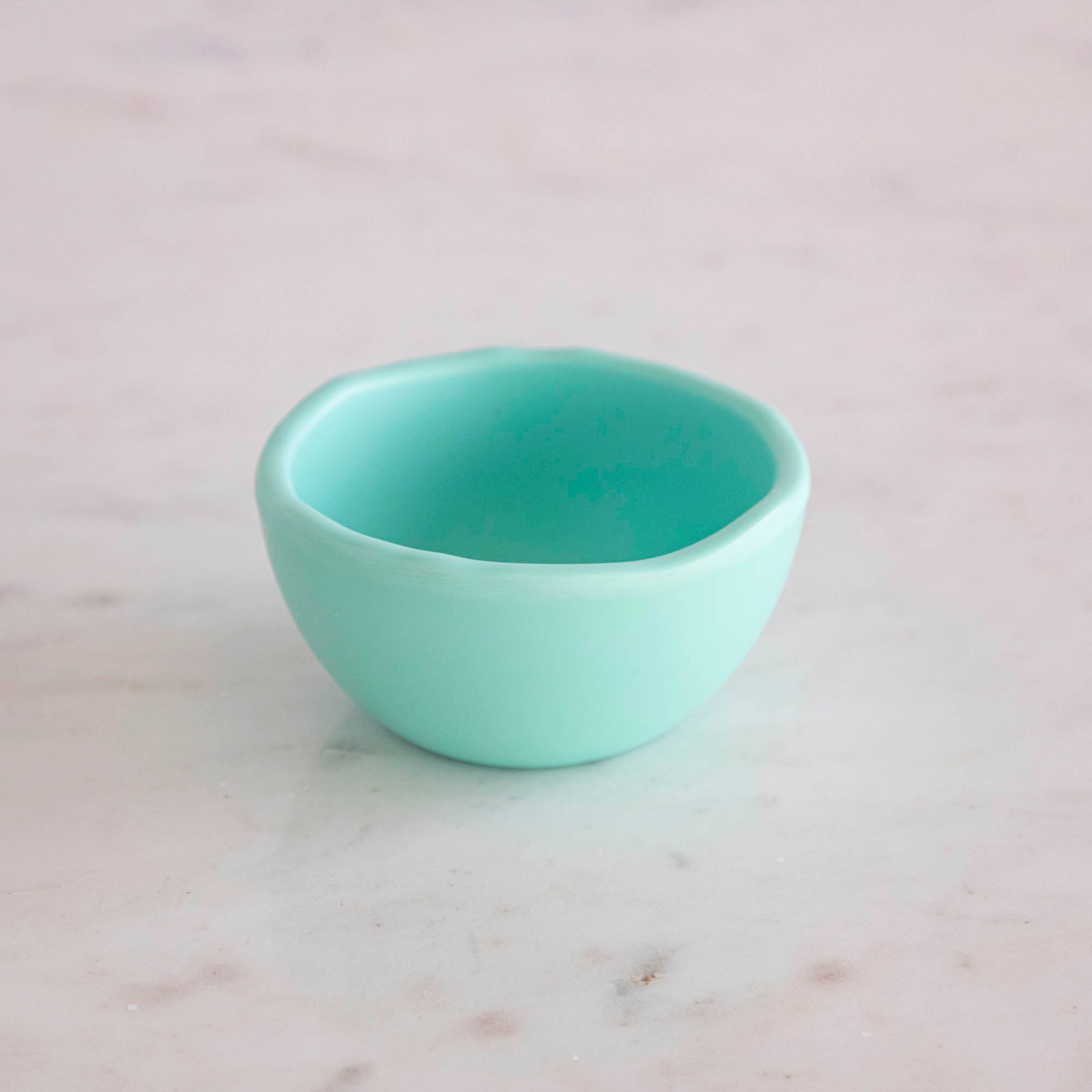 A set of colorful, dishwasher-safe Glitterville Rainbow Melamine Trinket Bowls on a table.