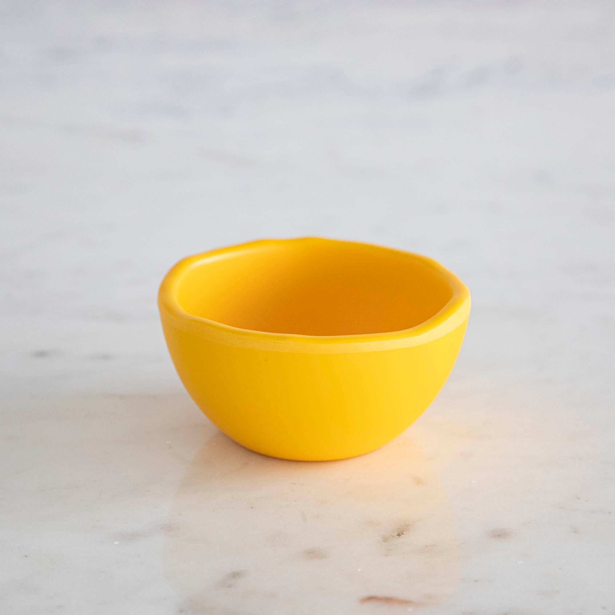 A set of colorful, dishwasher-safe Glitterville Rainbow Melamine Trinket Bowls on a table.