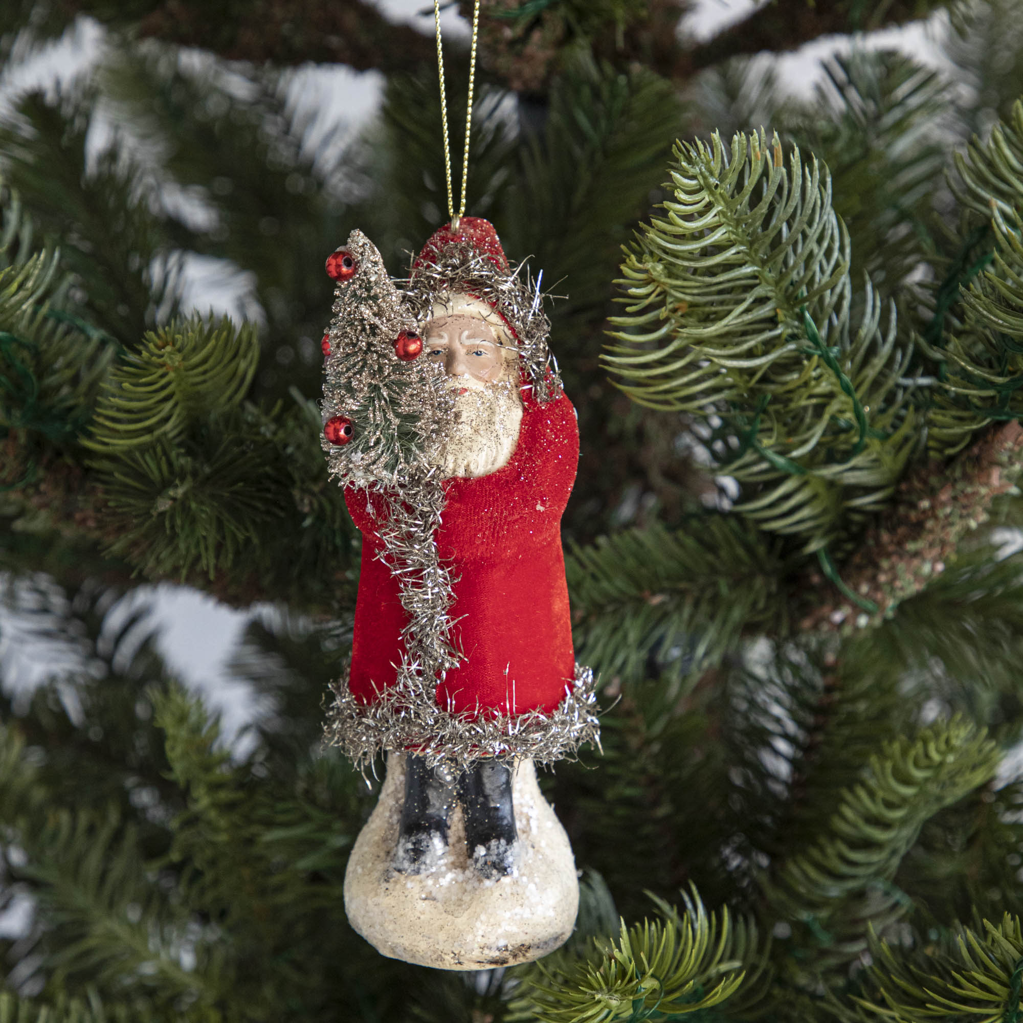 A red-robed Santa Claus ornament on a tree.