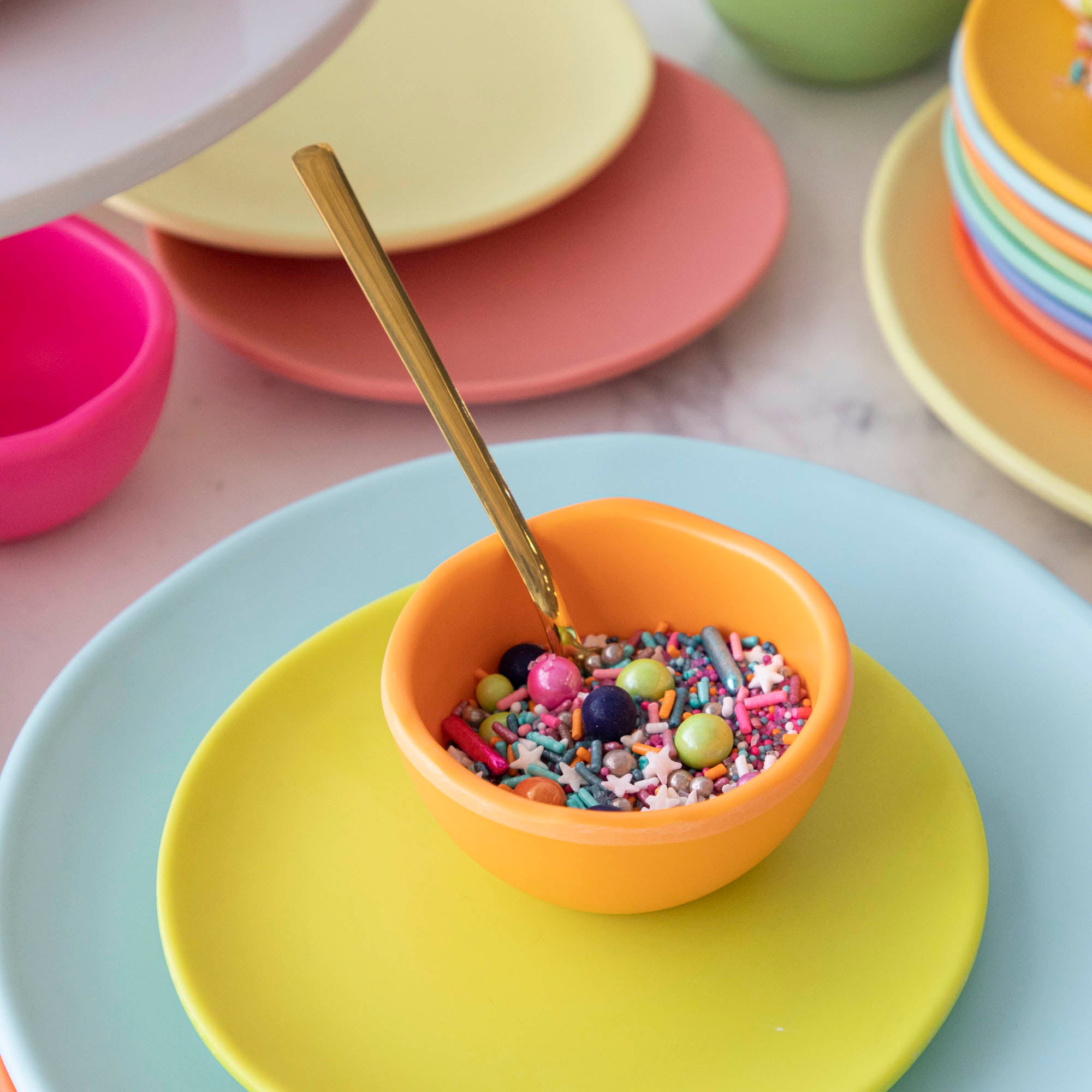 A set of colorful, dishwasher-safe Glitterville Rainbow Melamine Trinket Bowls on a table.