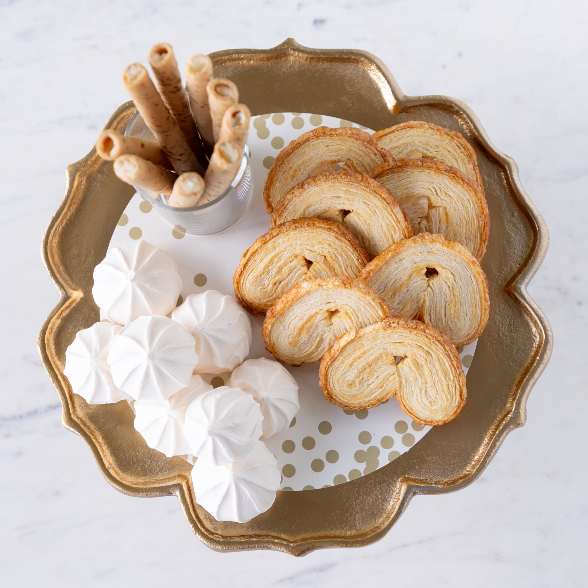 Scalloped Edge Cast Aluminum Cake Plate with the Gold Confetti Serving Paper, palmiers, meringues, and a small cup of wafers atop.