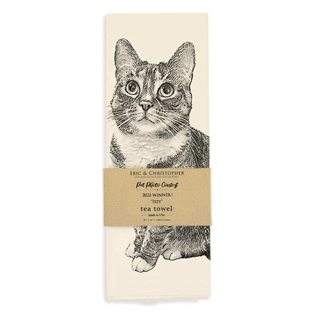 Illustration of a seated tabby cat on an Eric &amp; Christopher Izzy Tea Towel with a pale background.