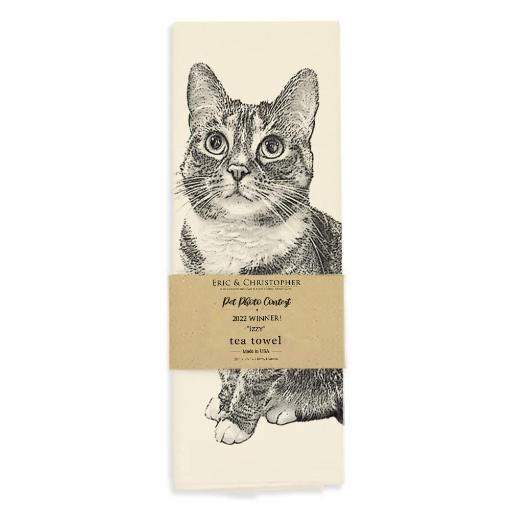 Illustration of a seated tabby cat on an Eric & Christopher Izzy Tea Towel with a pale background.