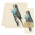 A high-quality fabric kitchen towel with a blue parakeet on it, the Eric & Christopher Blu Tea Towel.