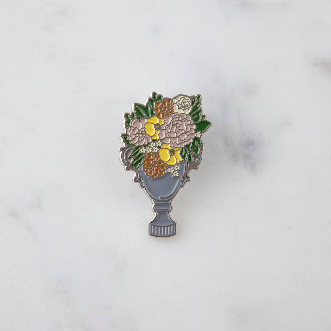 An Hester &amp; Cook enamel pin depicting a garden trophy with flowers in a vase, perfect for decorating a backpack.