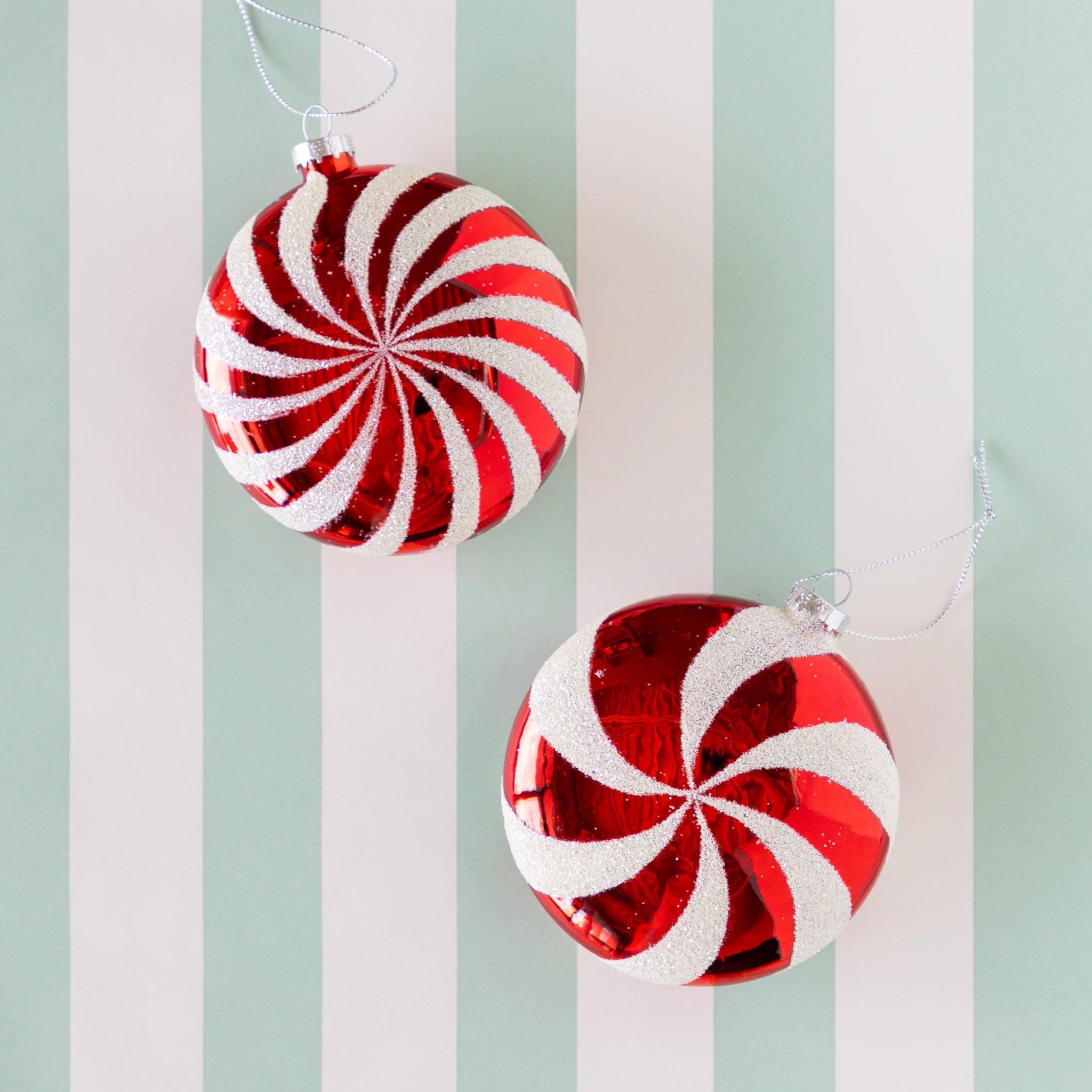 Two red and white striped Christmas ornaments on the Classic Seafoam Stripe Runner.
