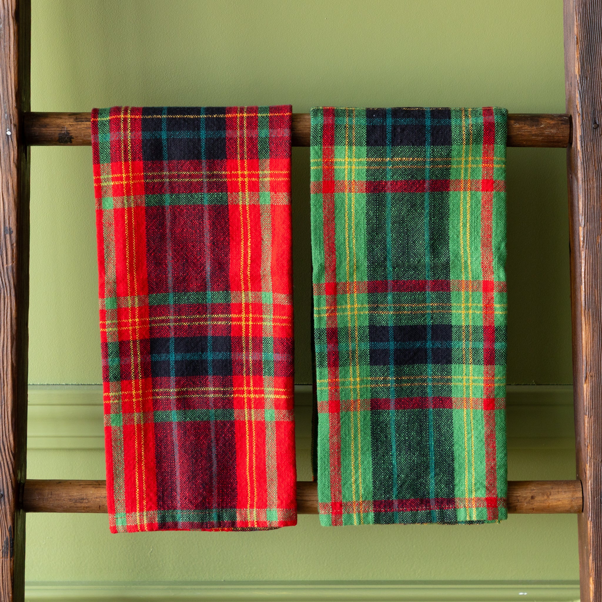 Holiday Plaid Dish Towels hung on a ladder.