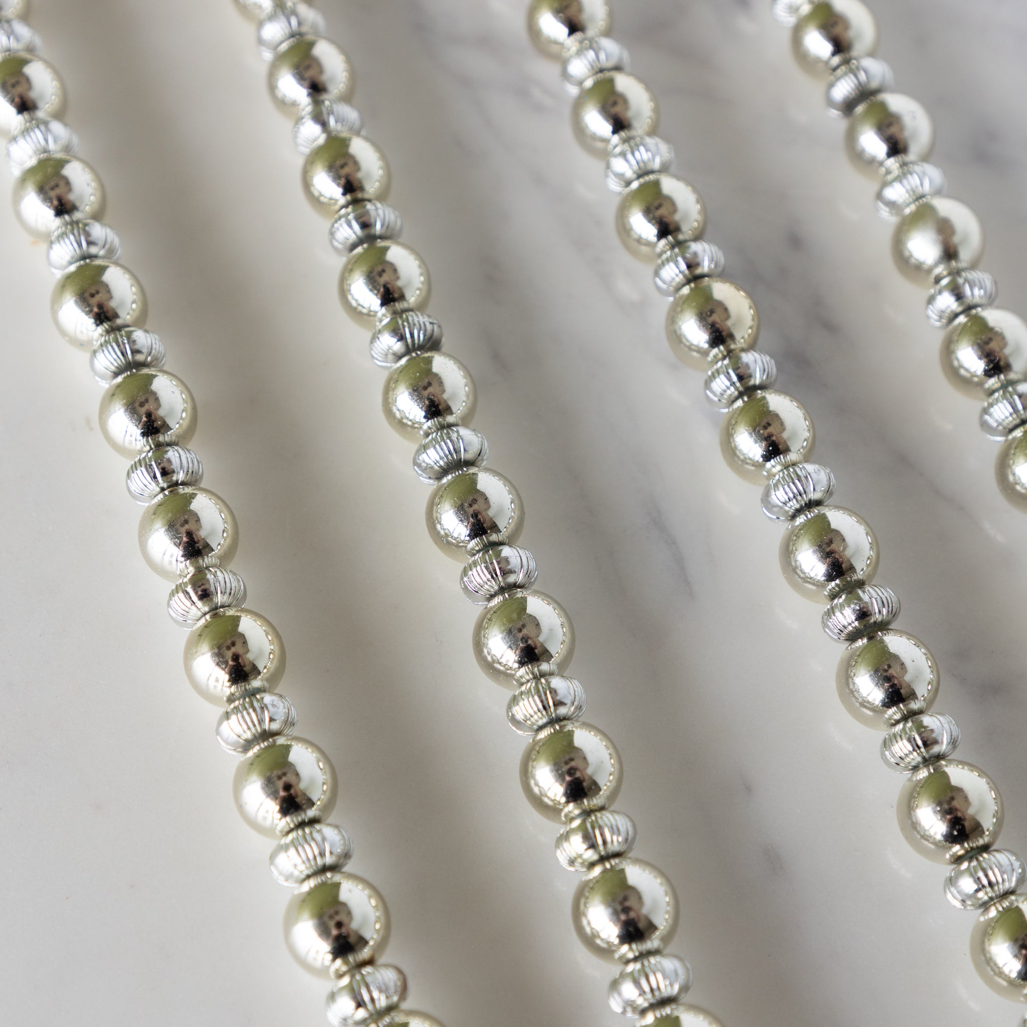 Close-up of Silver Bead Garland on a marble surface.