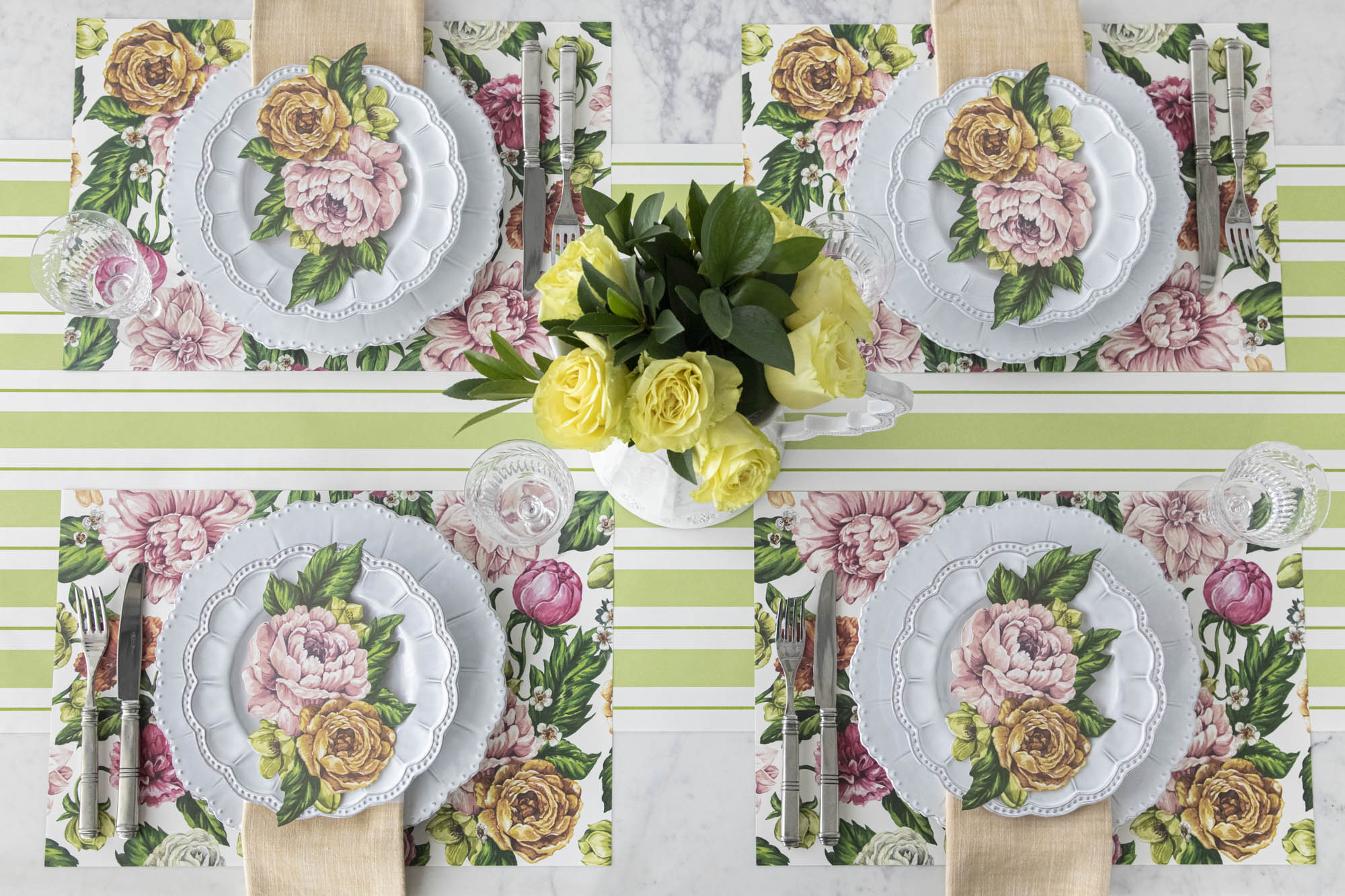 Top-down view of an elegant floral table setting for four, featuring a Garden Derby Table Accent resting on each plate.