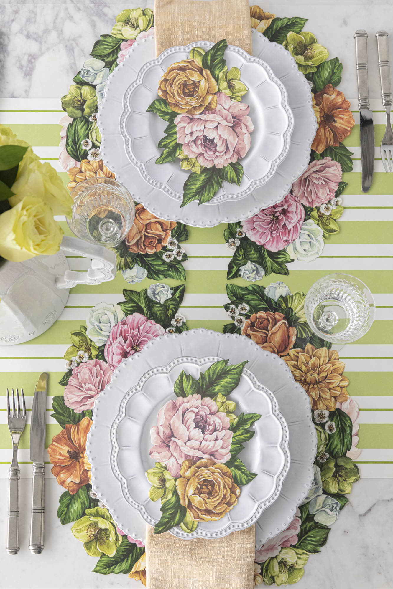Top-down view of an elegant floral table setting, featuring Garden Derby Table Accents resting on each plate.