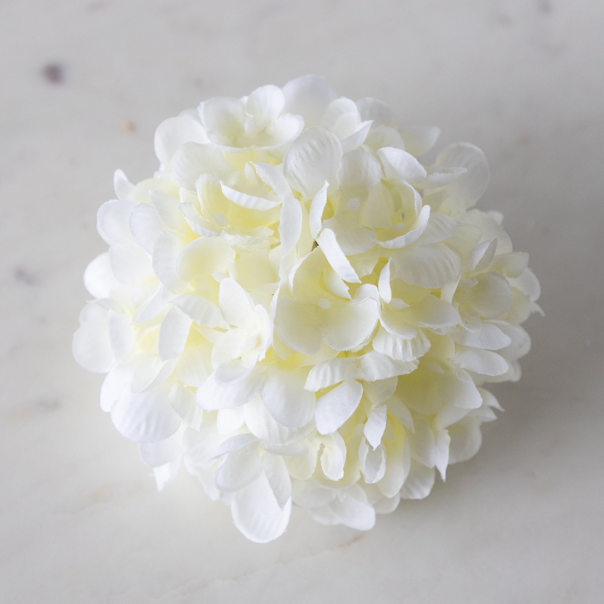 Cream Hydrangea Napkin Ring on a marble surface.
