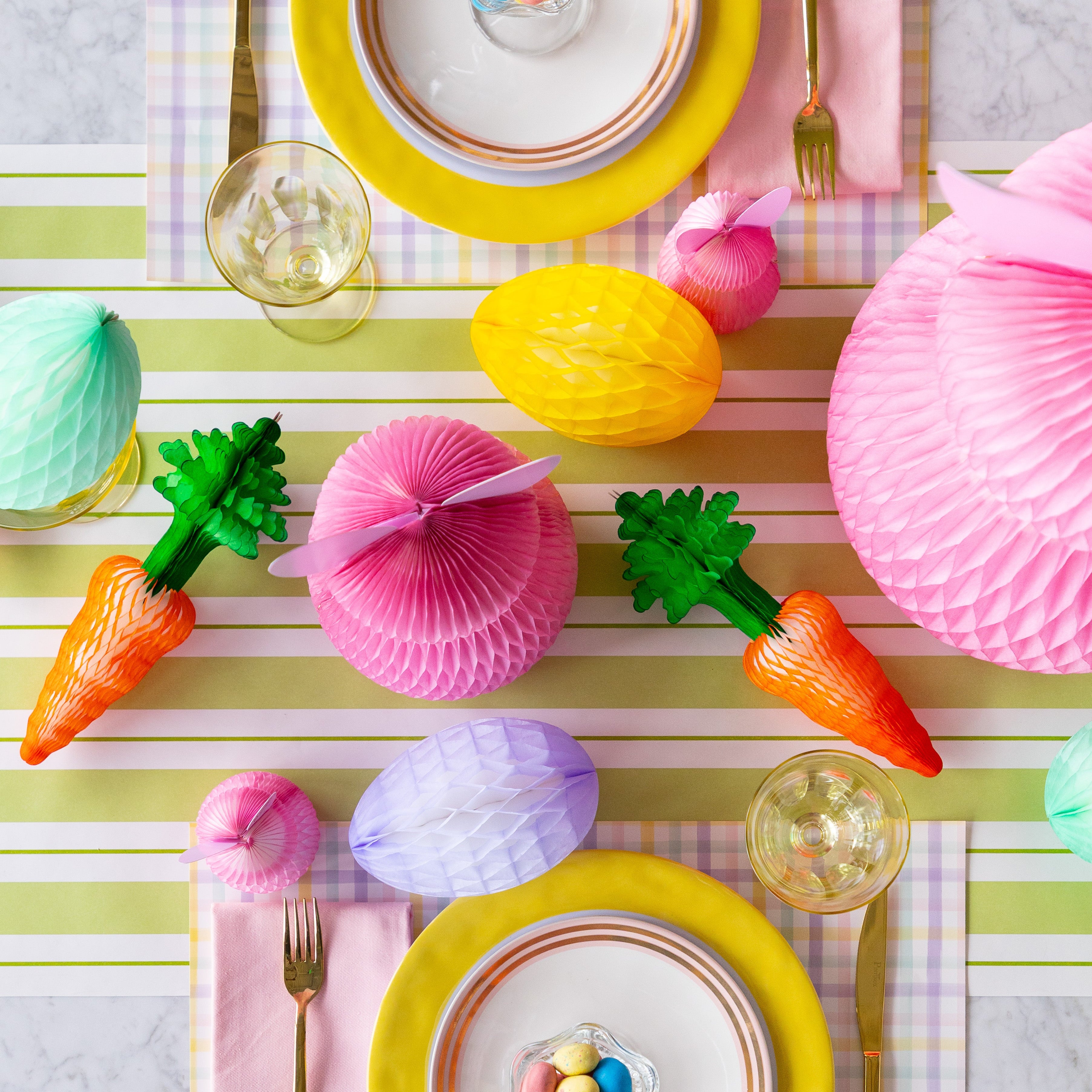 Colorful Easter table setting with Honeycomb Easter Eggs, bunnies and carrots.