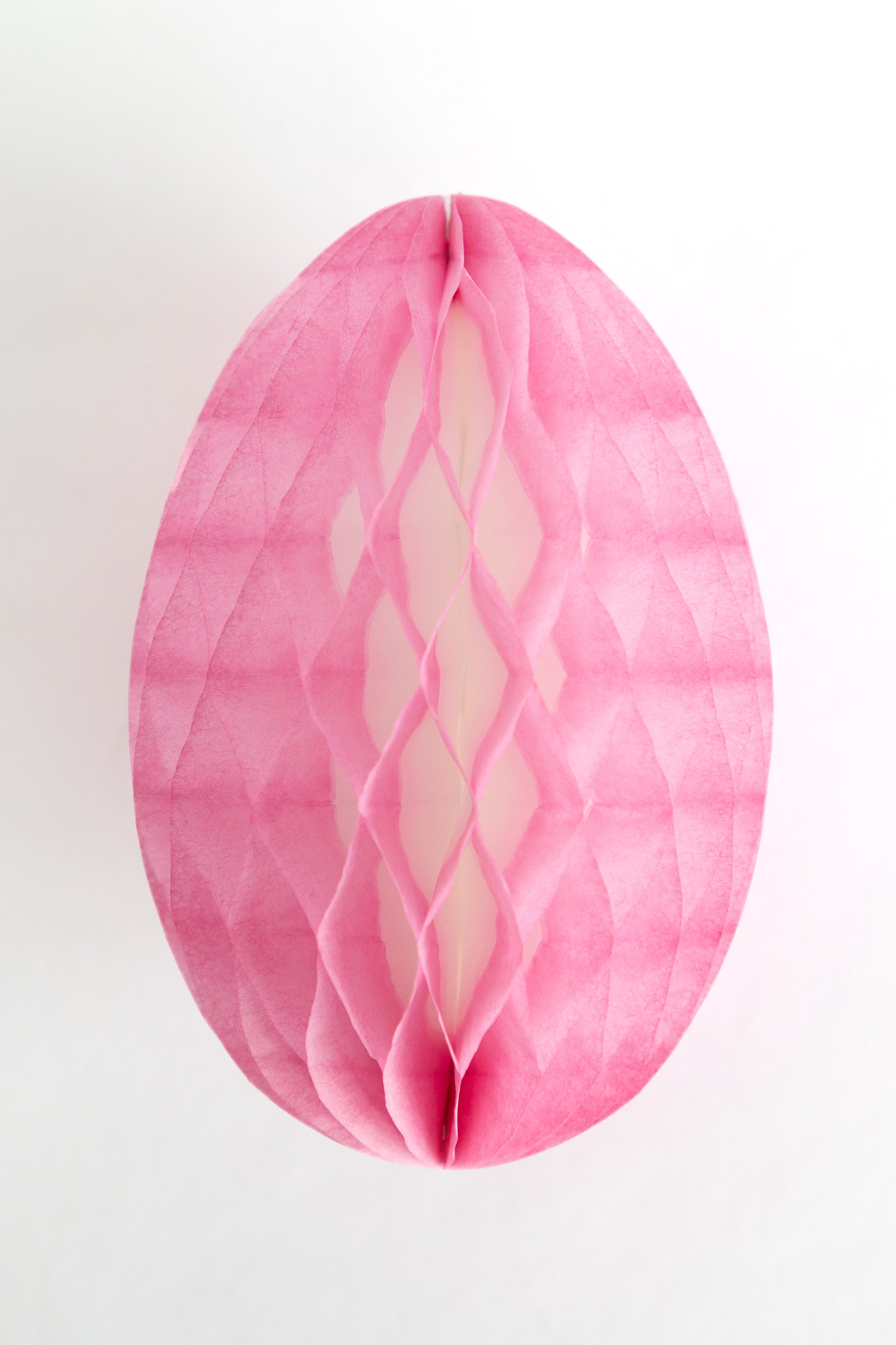 Pink honeycomb Easter egg on a white background.