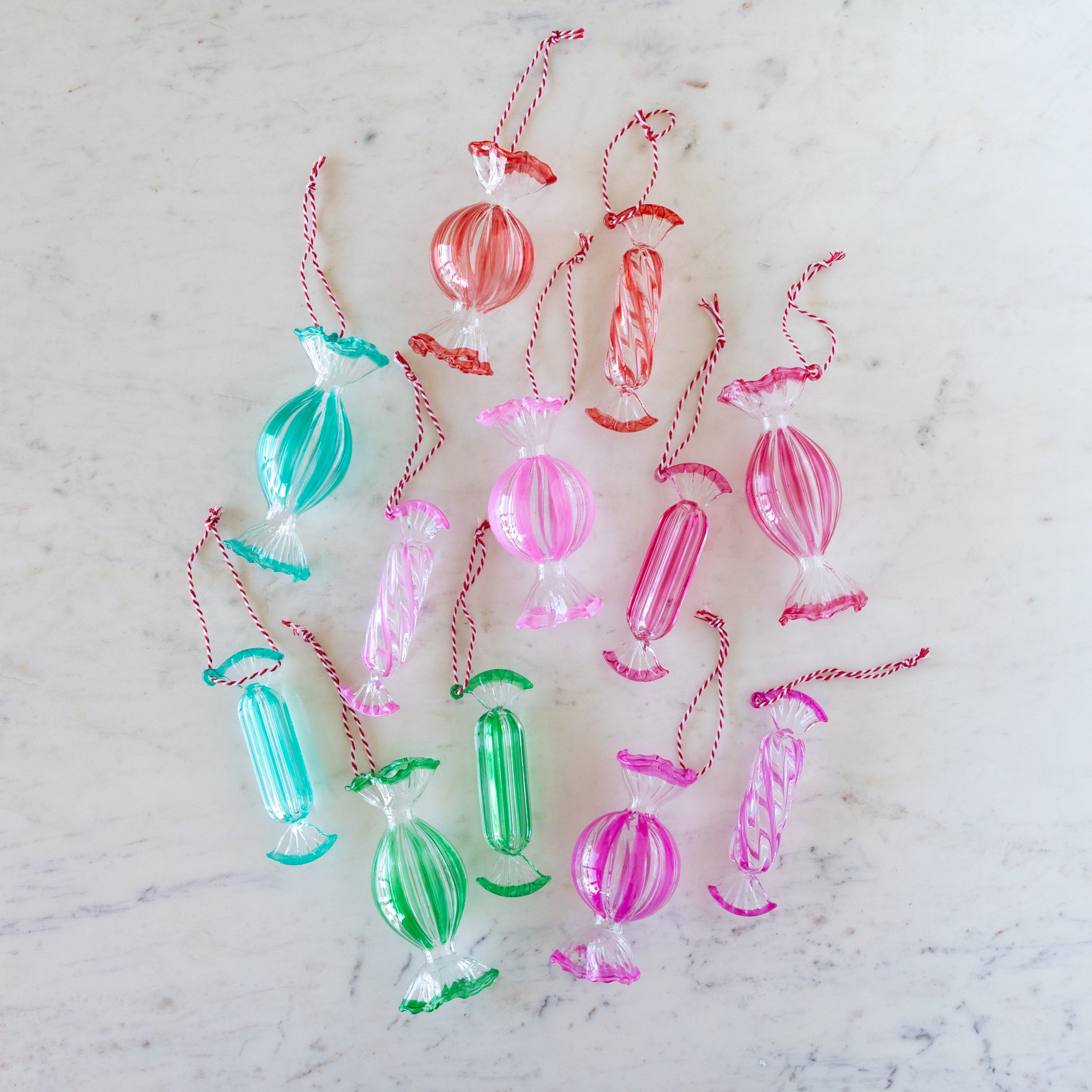 Colorful glass candy ornaments on a marble surface.