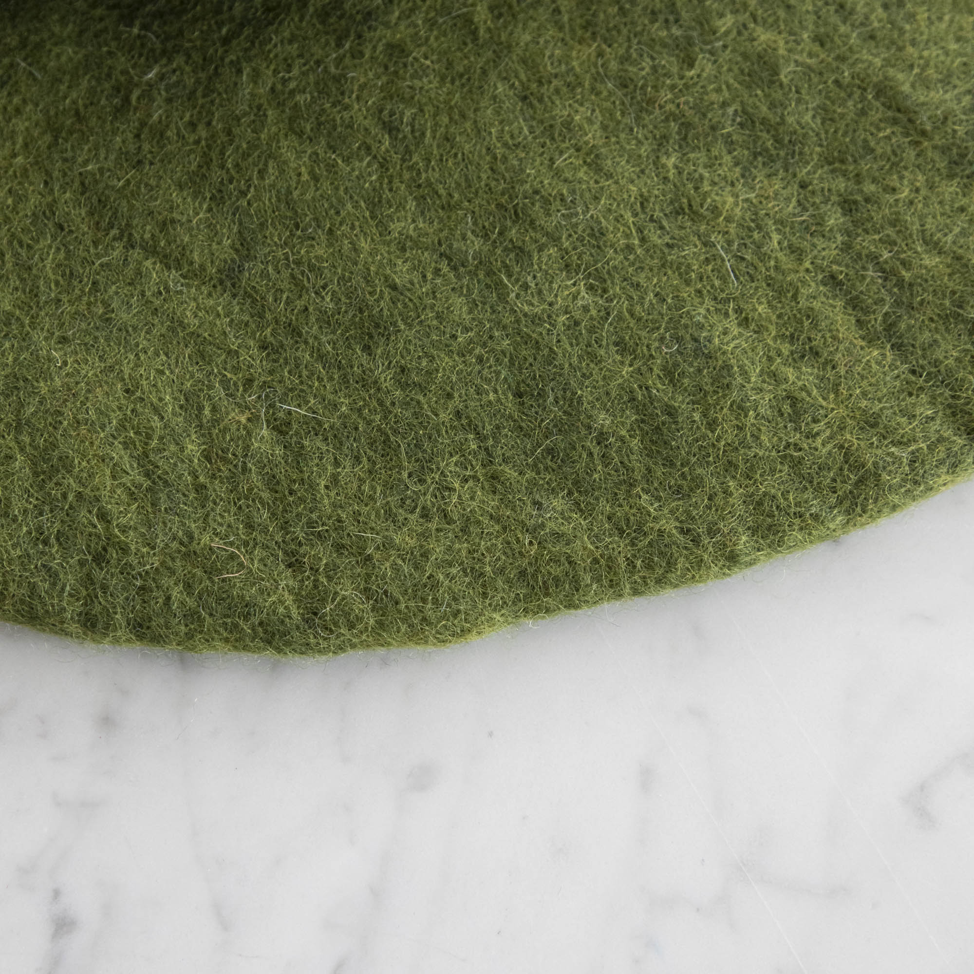 A close up of the Forest Green Felt Placemat showing the wool details.