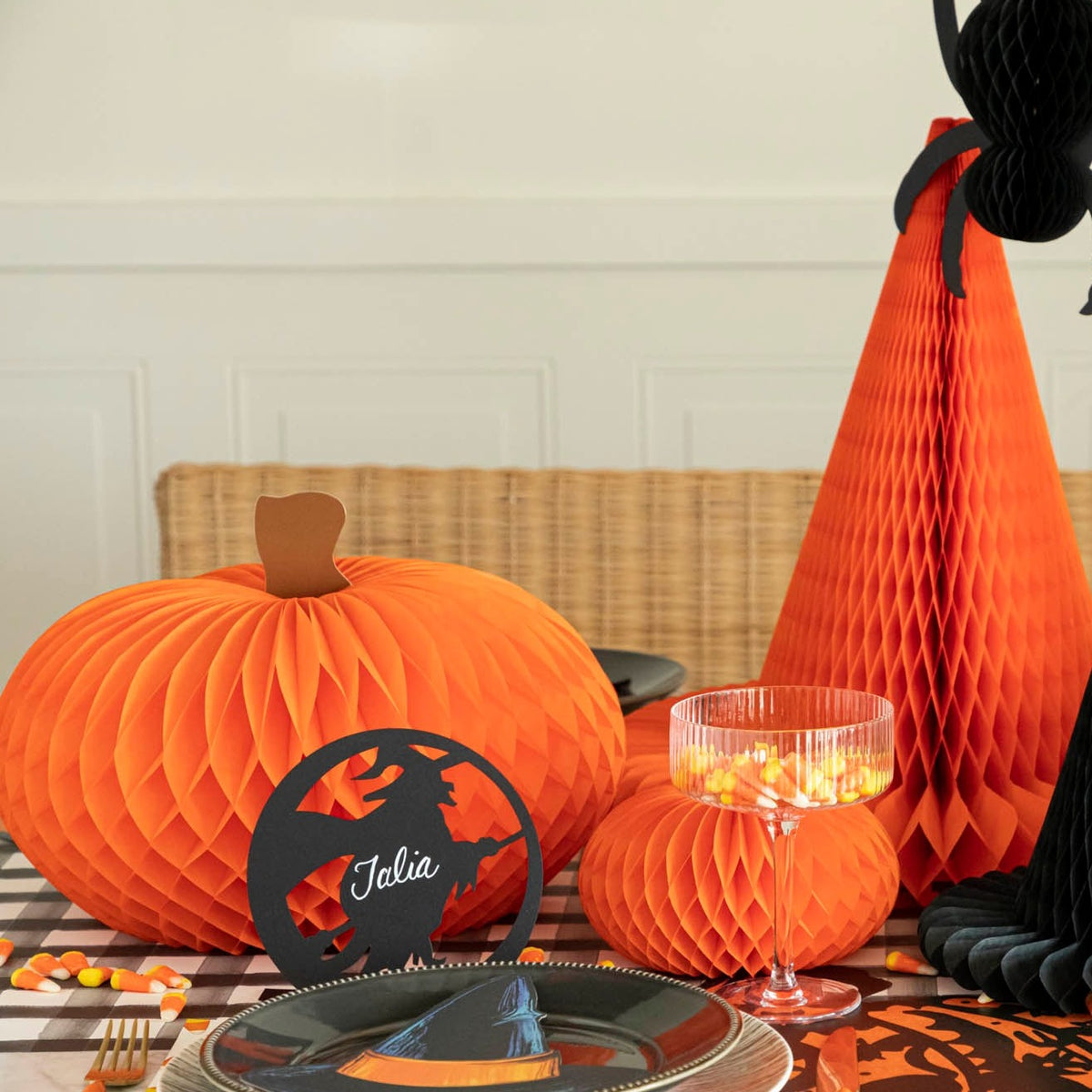 Orange honeycomb pumpkins on a Halloween themed table.
