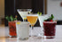 Assortment of five colorful cocktails displayed on a bar counter at Hester & Cook&