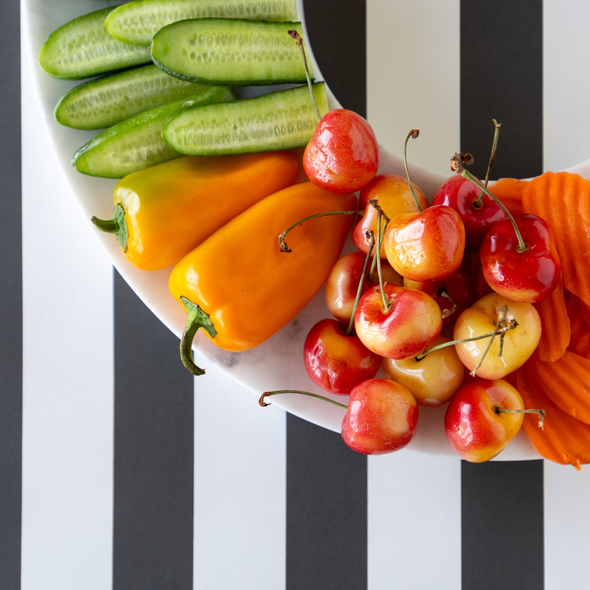 Assorted fruits and vegetables on the Marble Chip and Dip Server on the Black Classic Stripe Runner.