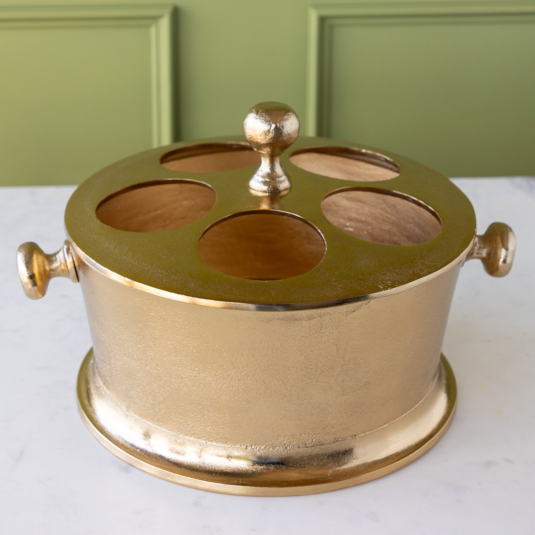 Gold Raw Aluminum Bottle Holder with a knob in the center and on both sides of the bucket.