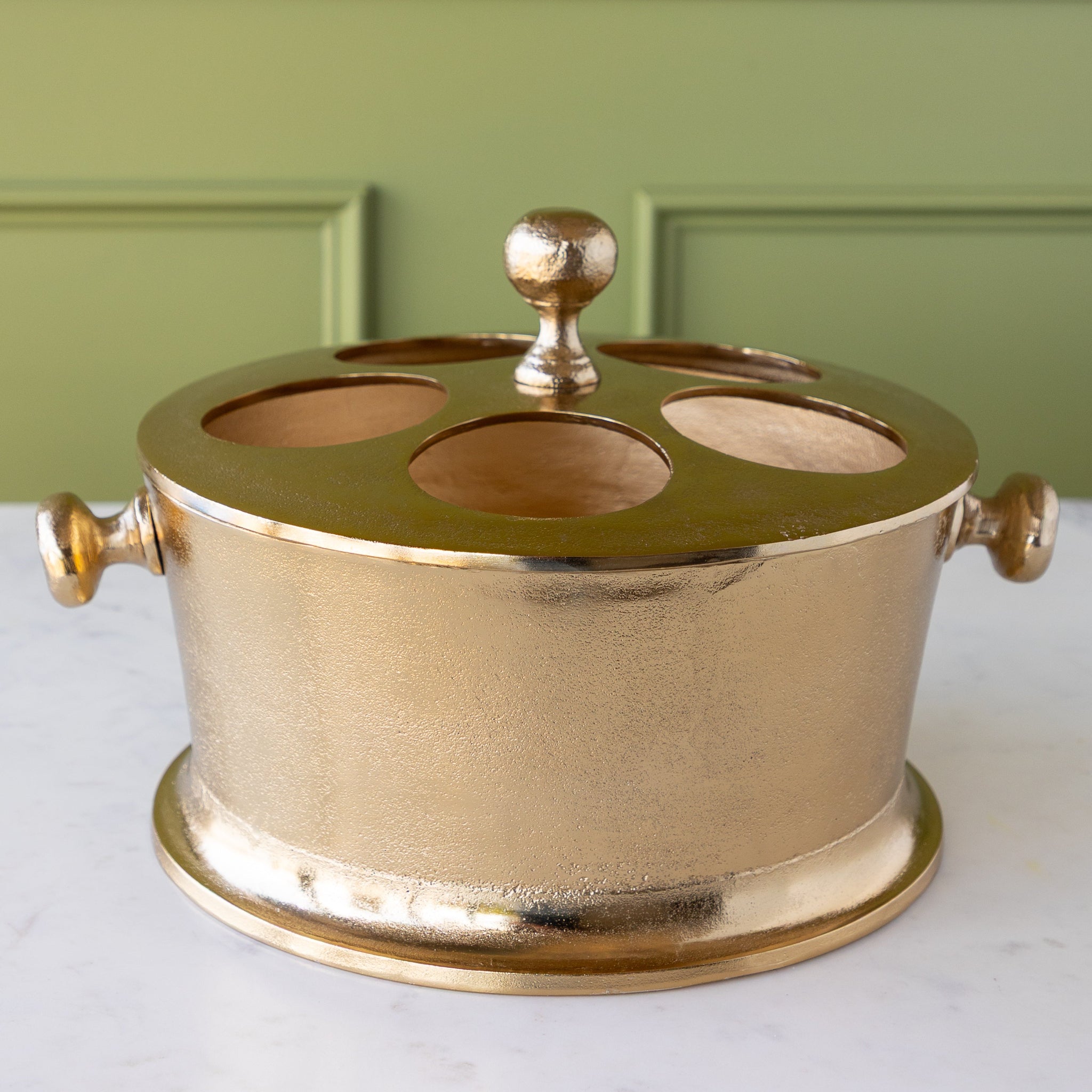 Gold Raw Aluminum Bottle Holder with a knob in the center and on both sides of the bucket.