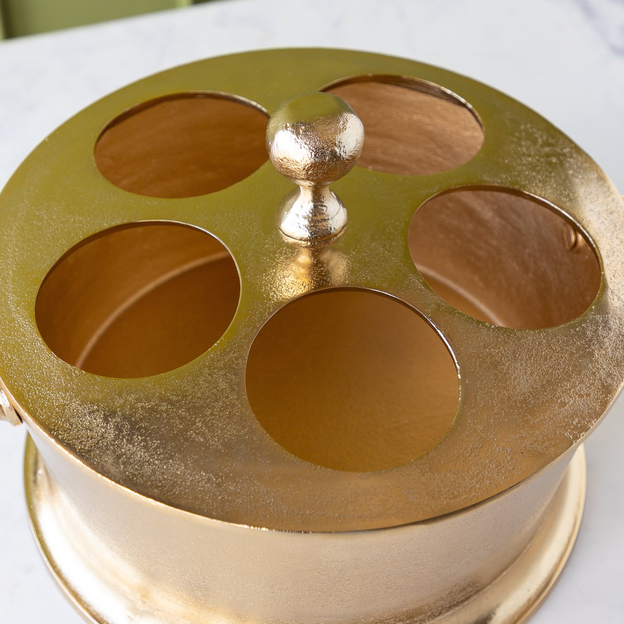 Gold Raw Aluminum Bottle Holder with a knob in the center and 5 circular holes.
