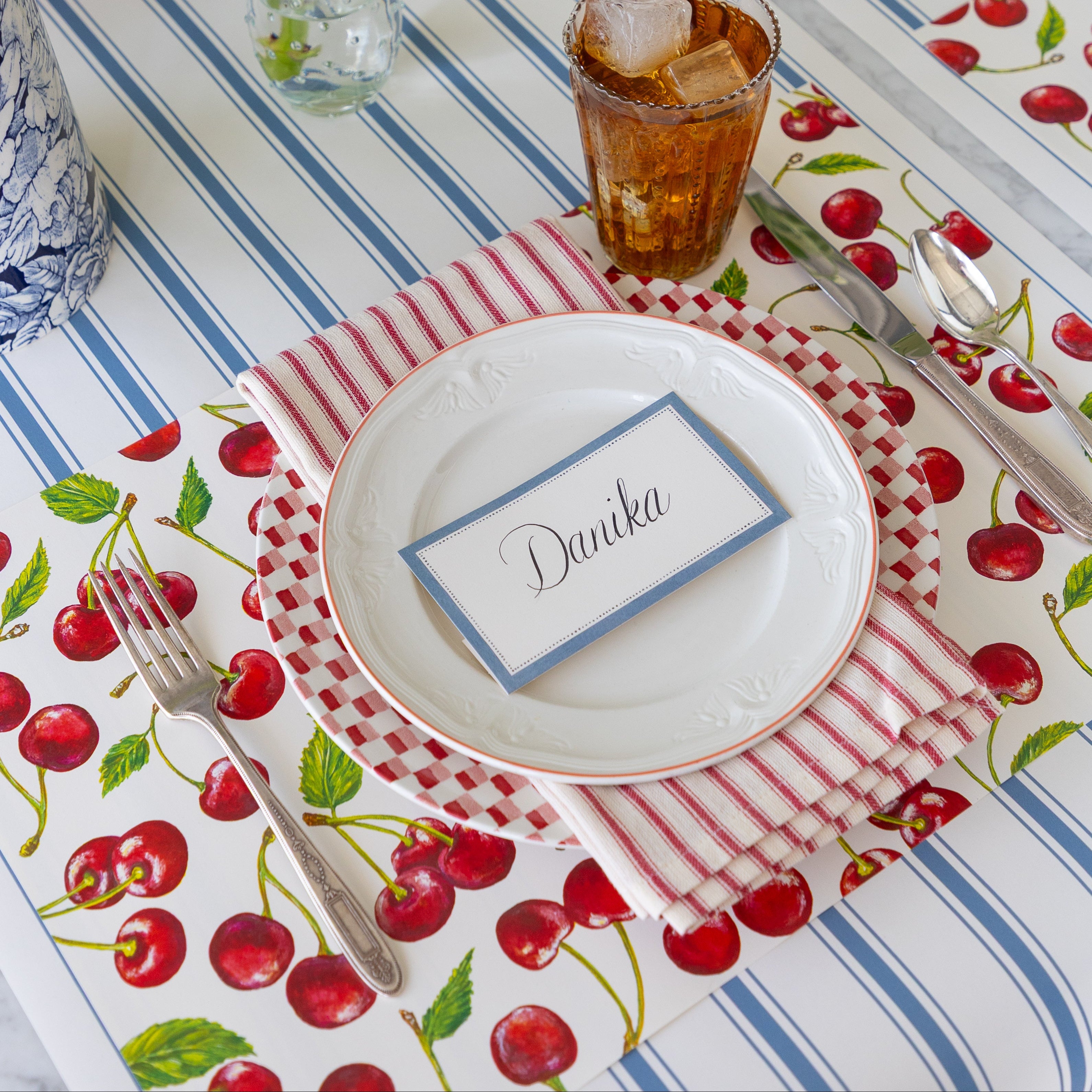 Table setting with the Cherries Placemat, Cornflower Blue Place Card, vintage dinnerware, and floral decorations on the Cornflower Blue Linen Stripe Runner.