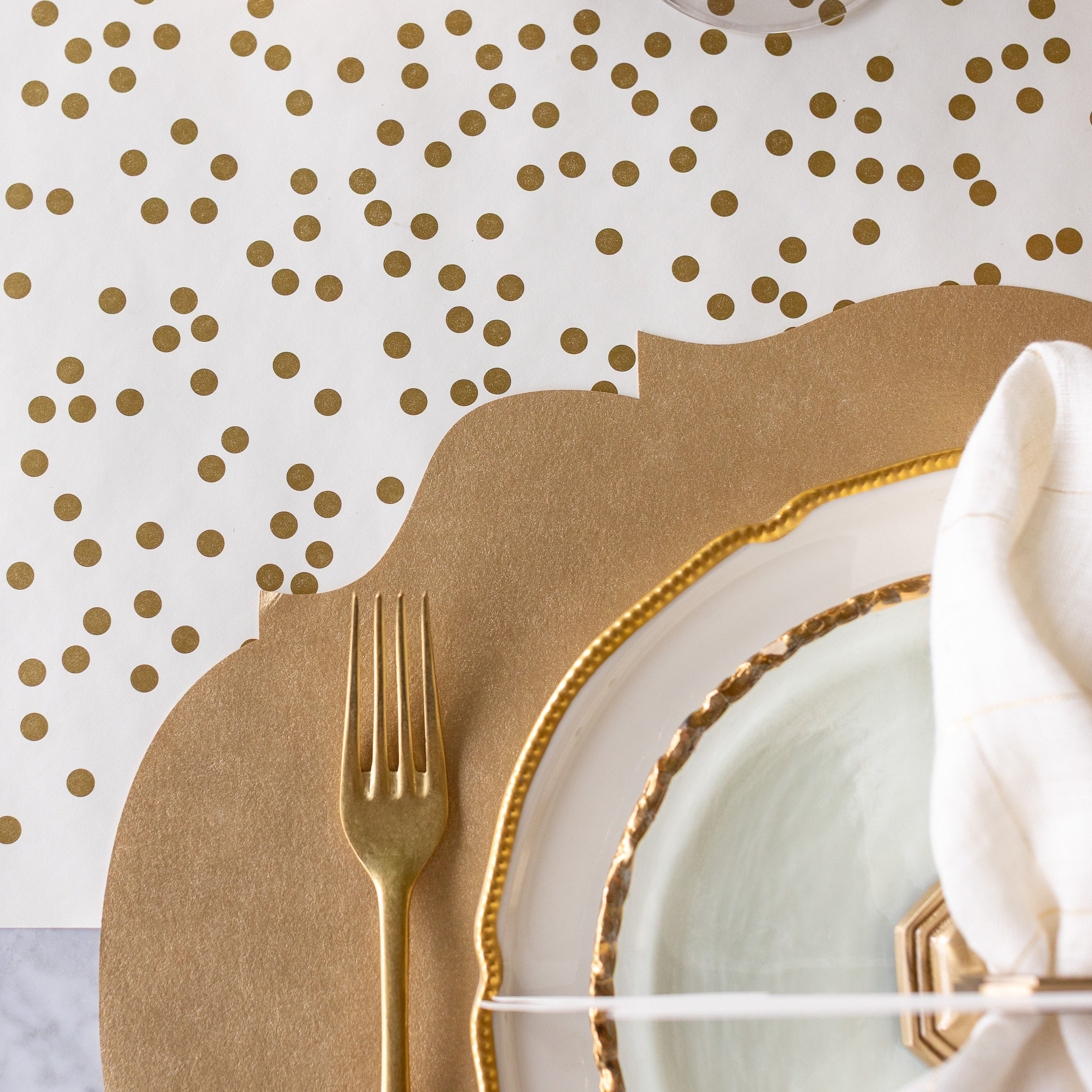 A place setting featuring the Die-cut Gold French Frame Placemat on the Gold Confetti Runner.