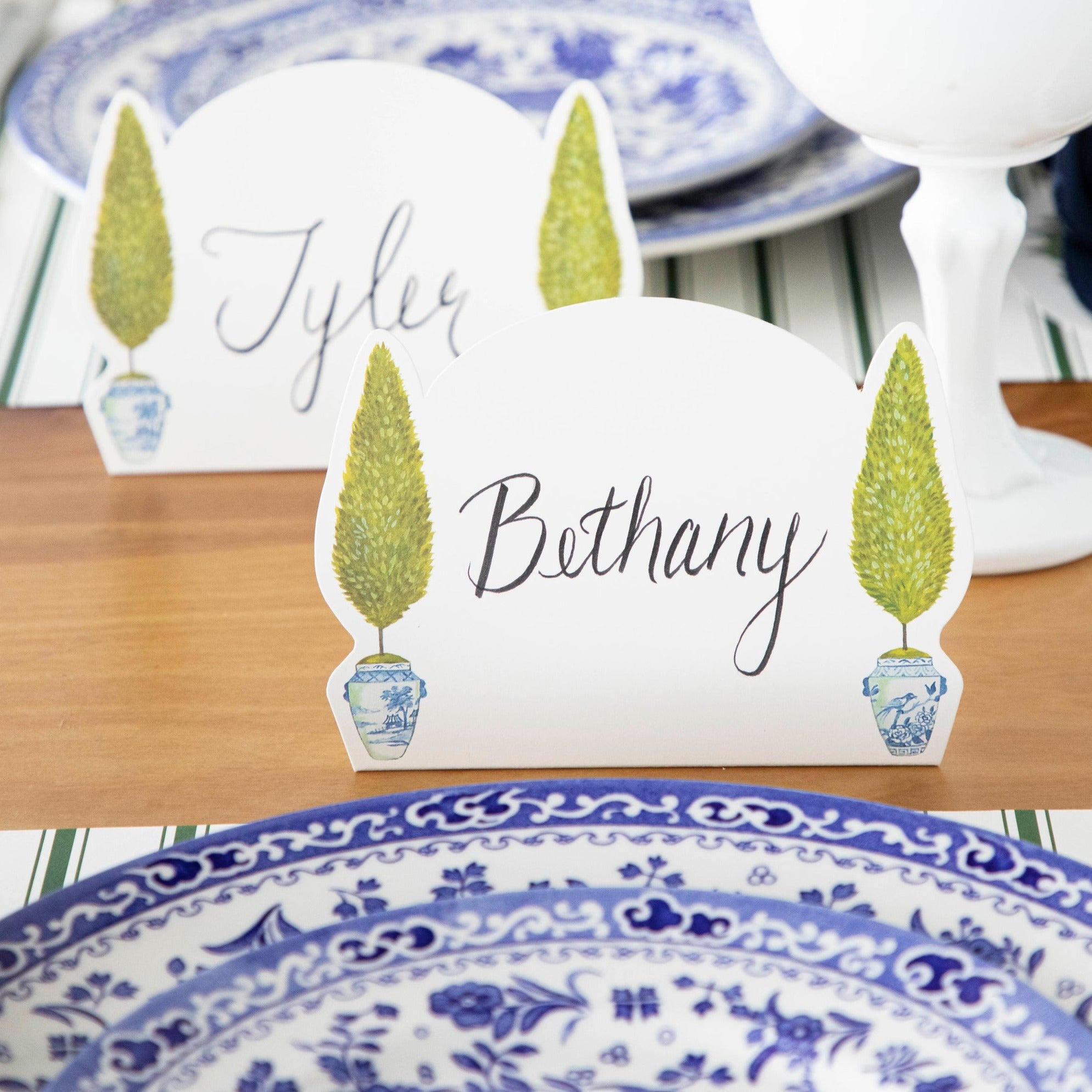 Two Topiary Place Cards labeled "Tyler" and "Bethany" standing on an elegant table setting.