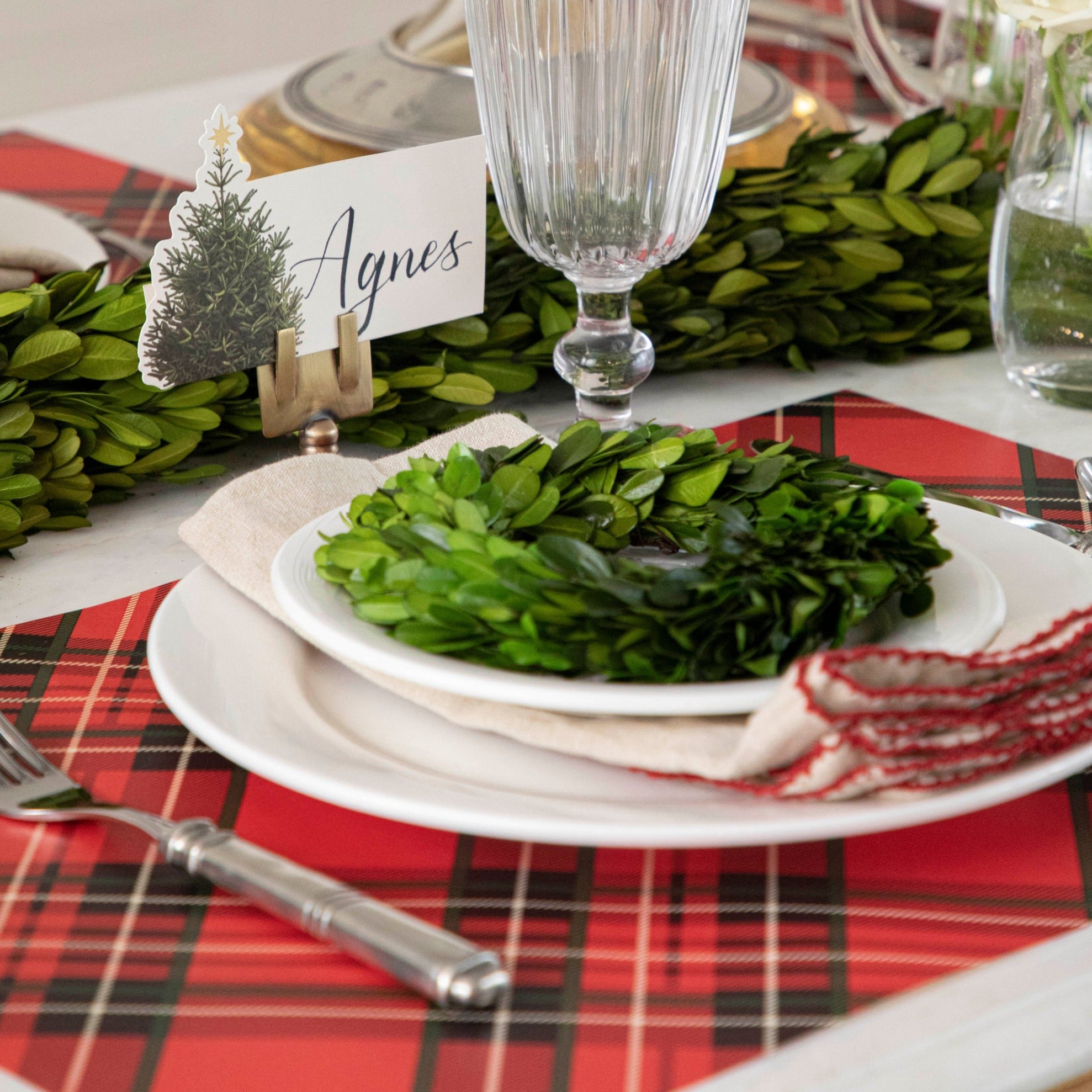 The Red Plaid Placemat under a festive holiday-themed table setting.