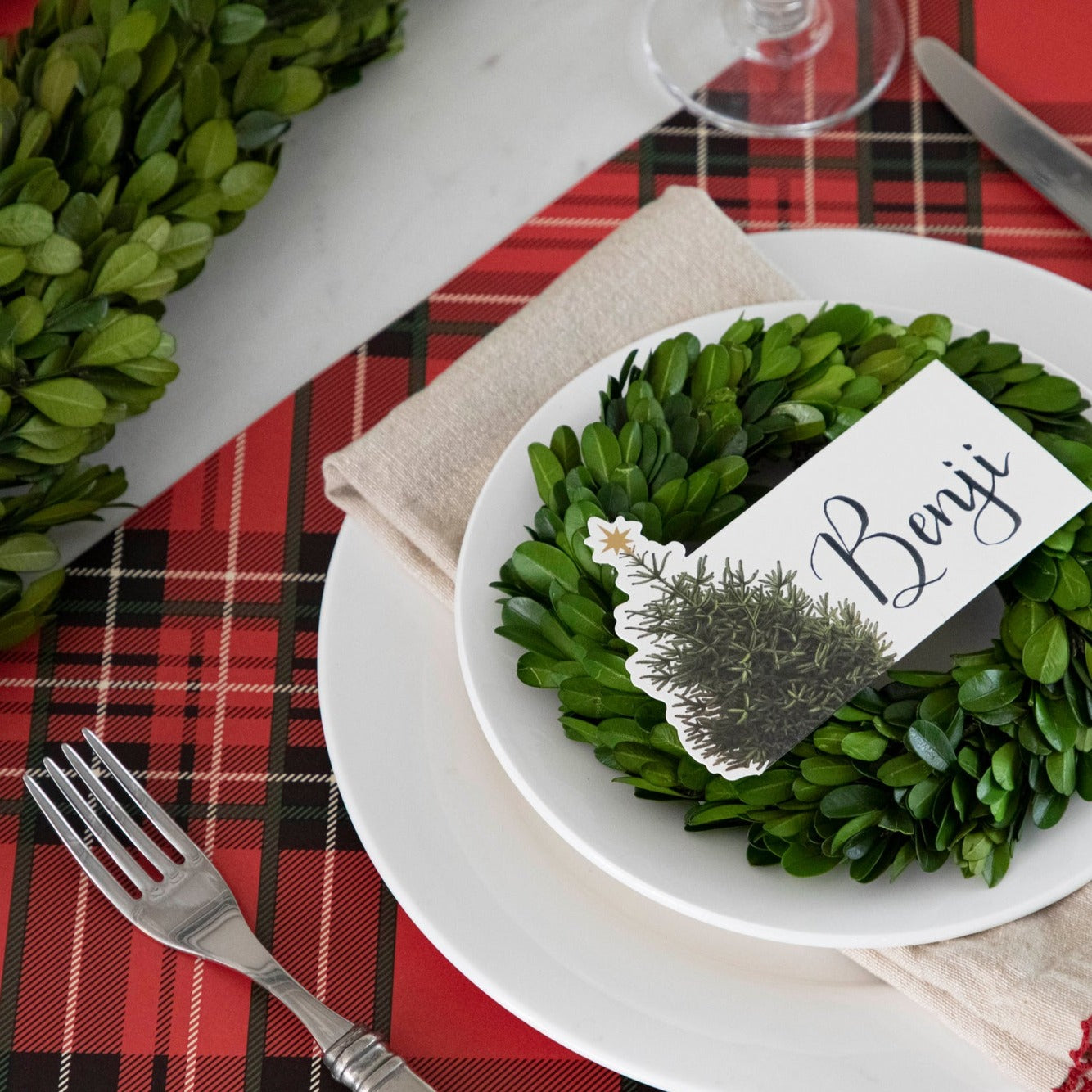 Close-up of the Red Plaid Placemat under a festive holiday-themed place setting.