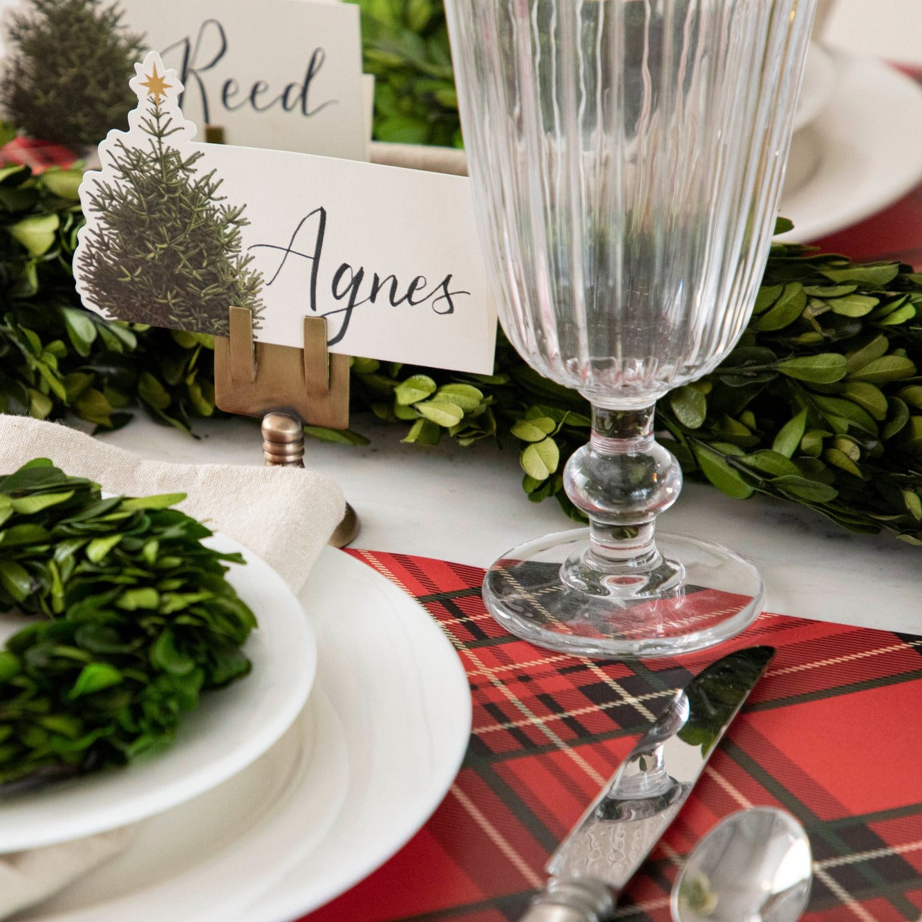 Close-up of the Red Plaid Placemat under a festive holiday-themed place setting.