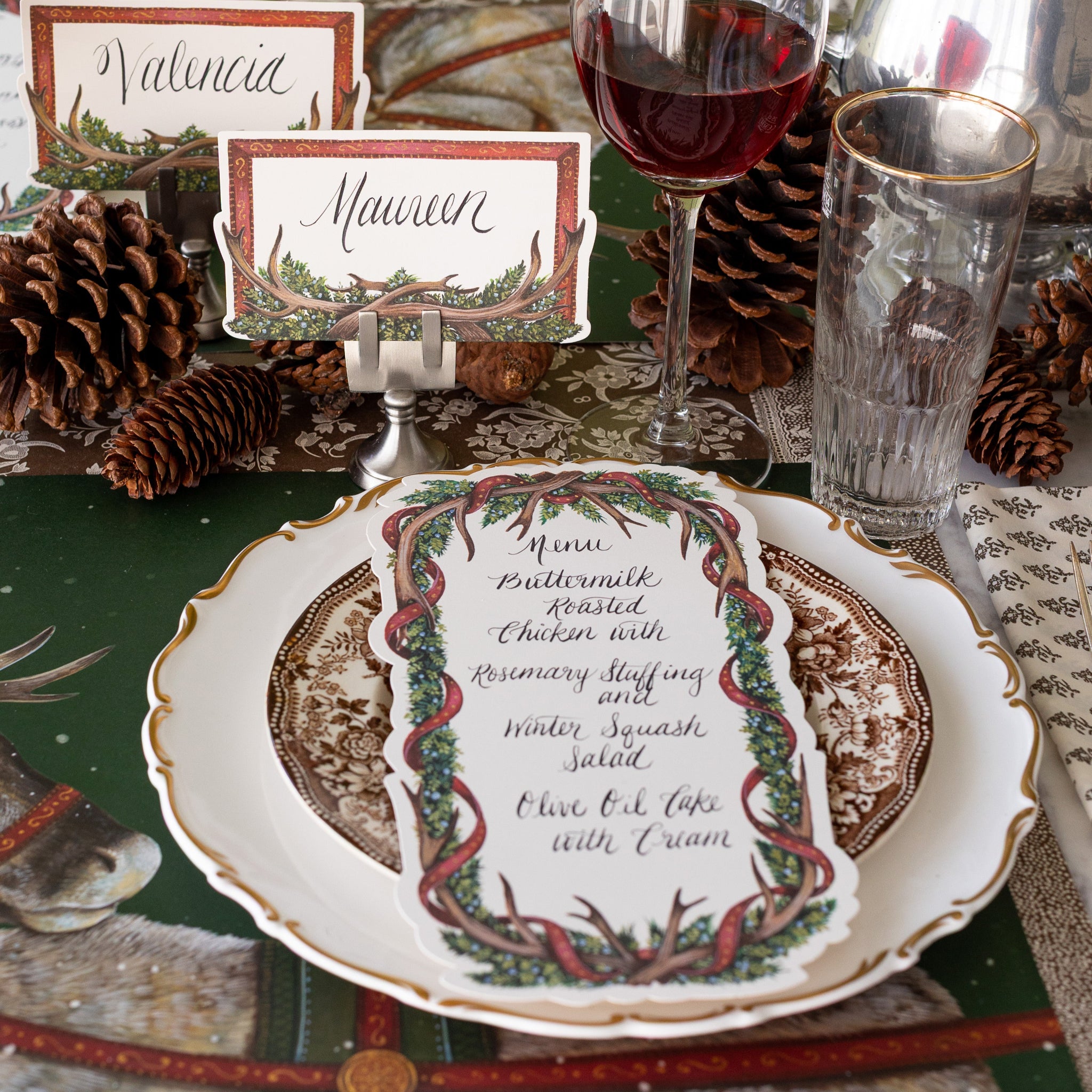 The Antler Frame Place Cards held by a place card holder, behind a place setting.