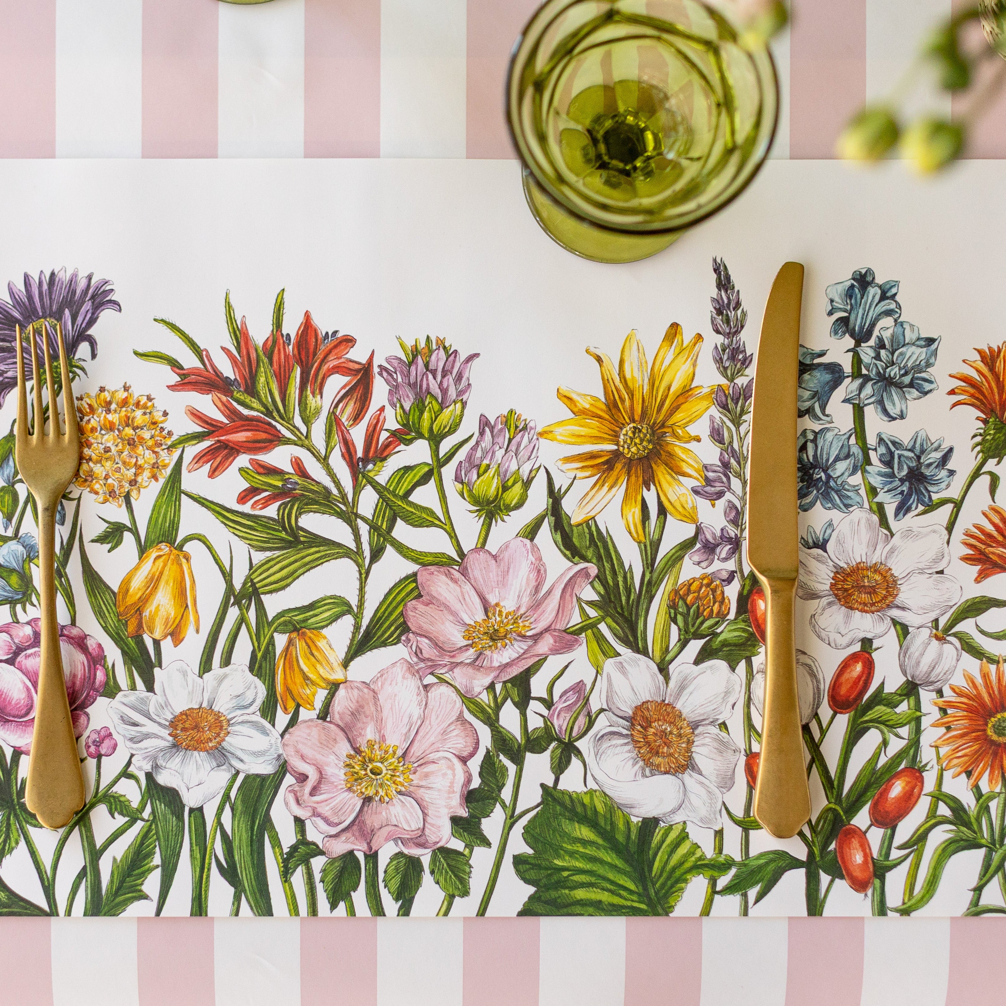 The Wildflower Meadow Placemat with gold flatware on top and the Pink Classic Stripe Runner underneath.