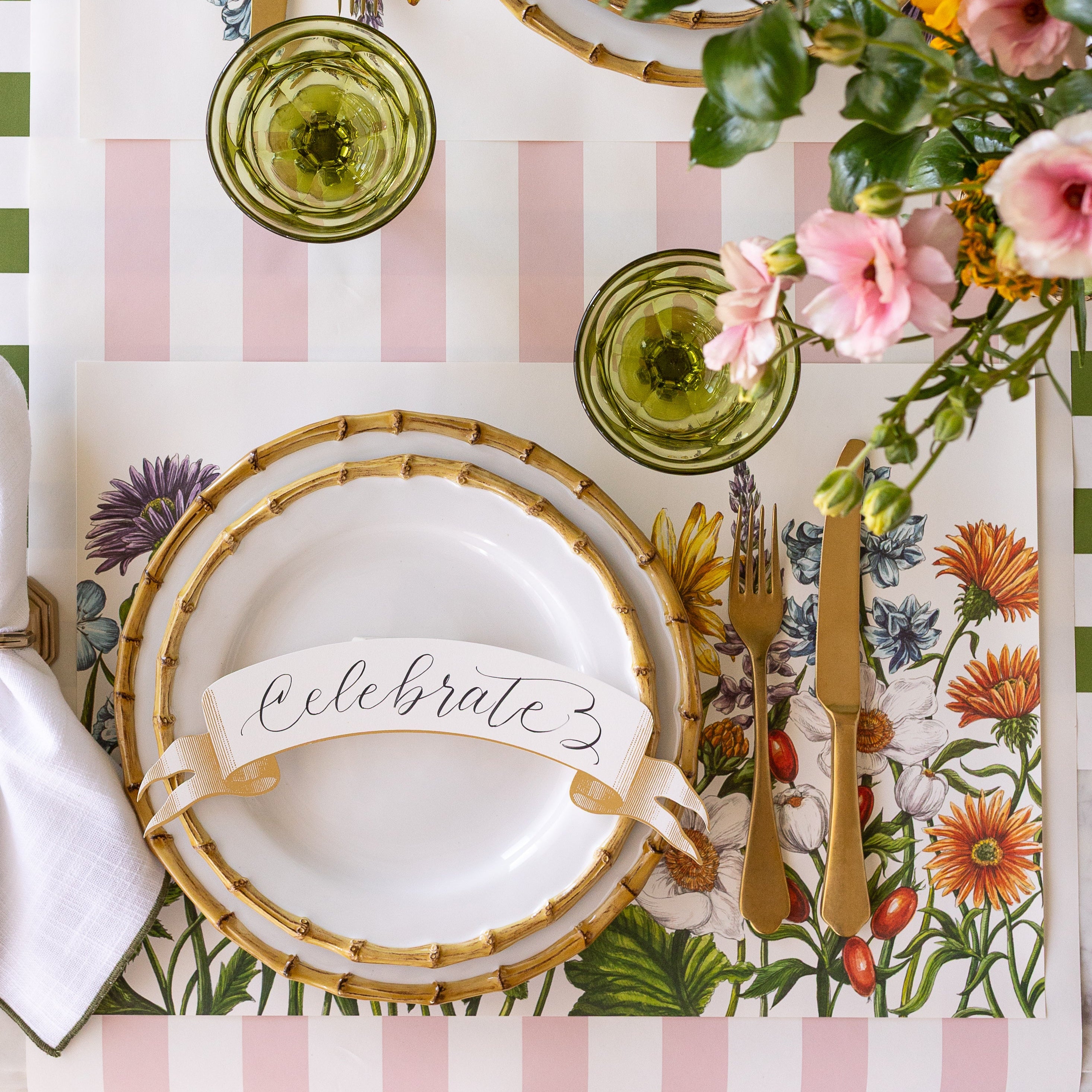 A spring place setting with the Wildflower Meadow Placemat under bamboo dinnerware with the Gold Banner Table Accent on top.