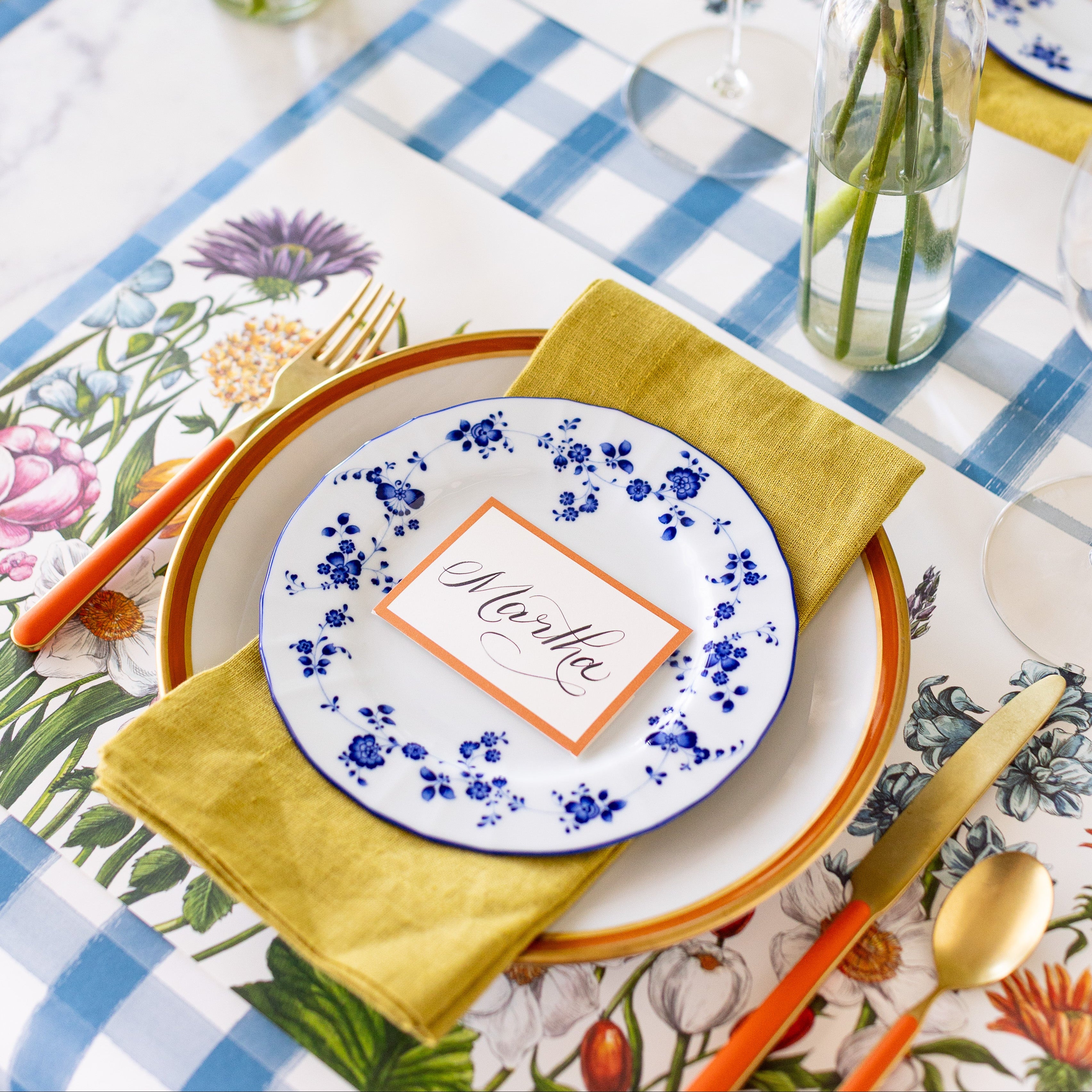 A spring place setting with the Wildflower Meadow Placemat on the Blue Painted Check Runner.