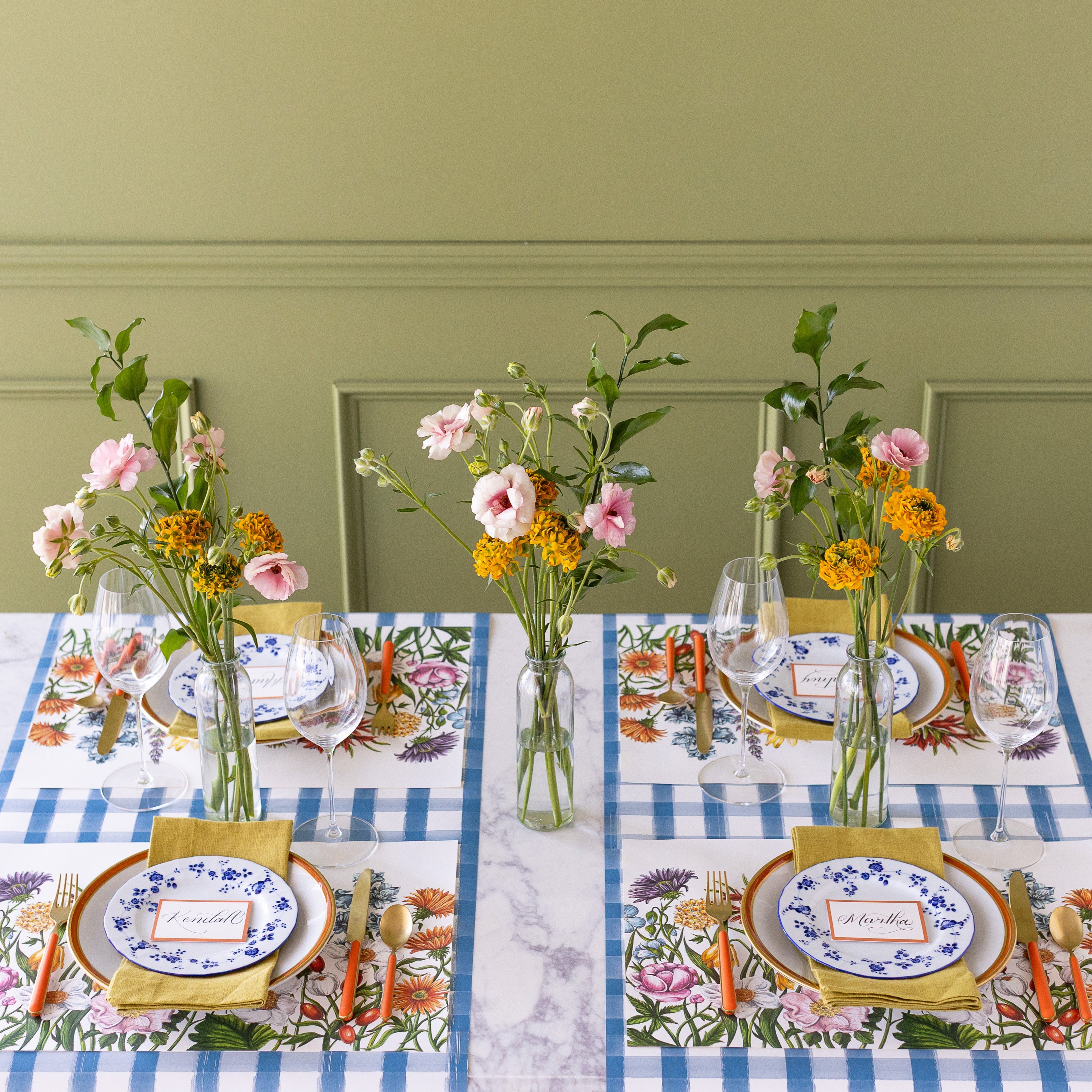 A spring table setting for four with wildflowers featuring the Wildflower Meadow Placemat on the Blue Painted Check Runner.
