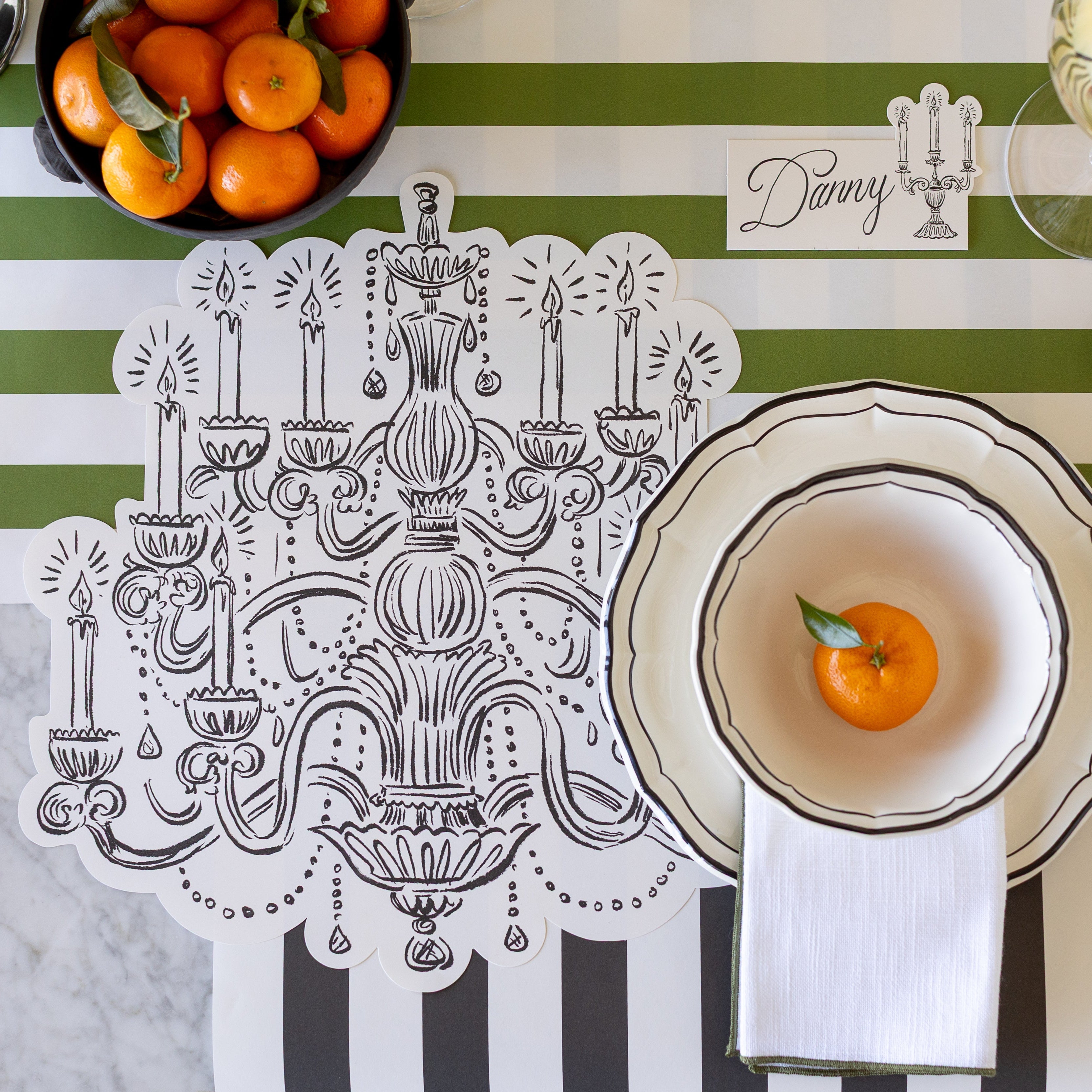 An elegant place setting next to the Die-cut Chandelier Placemat and Candelabra Place Card.