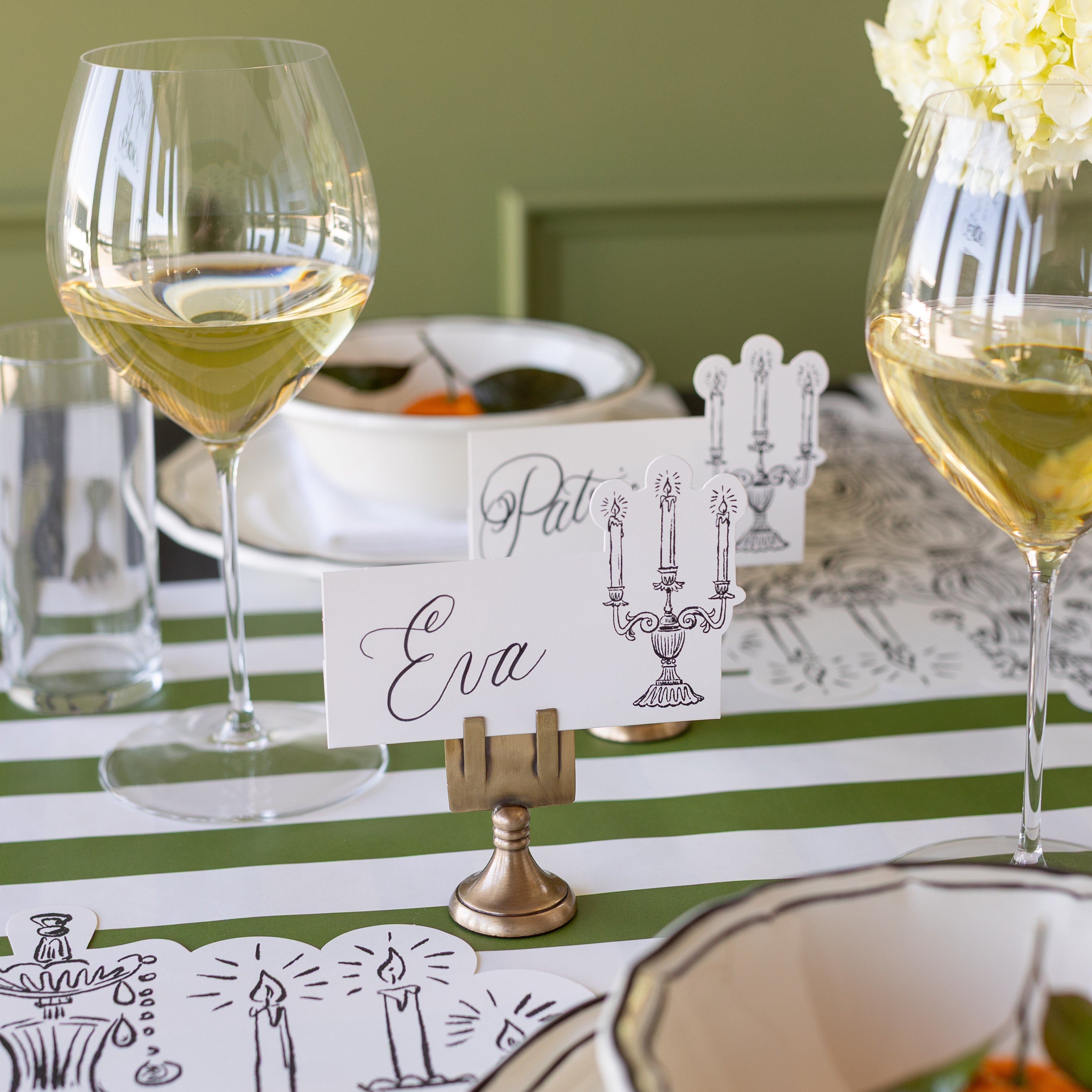 The Silver Place Card Holder holding the Candelabra Place Card with "Eva" written on it.