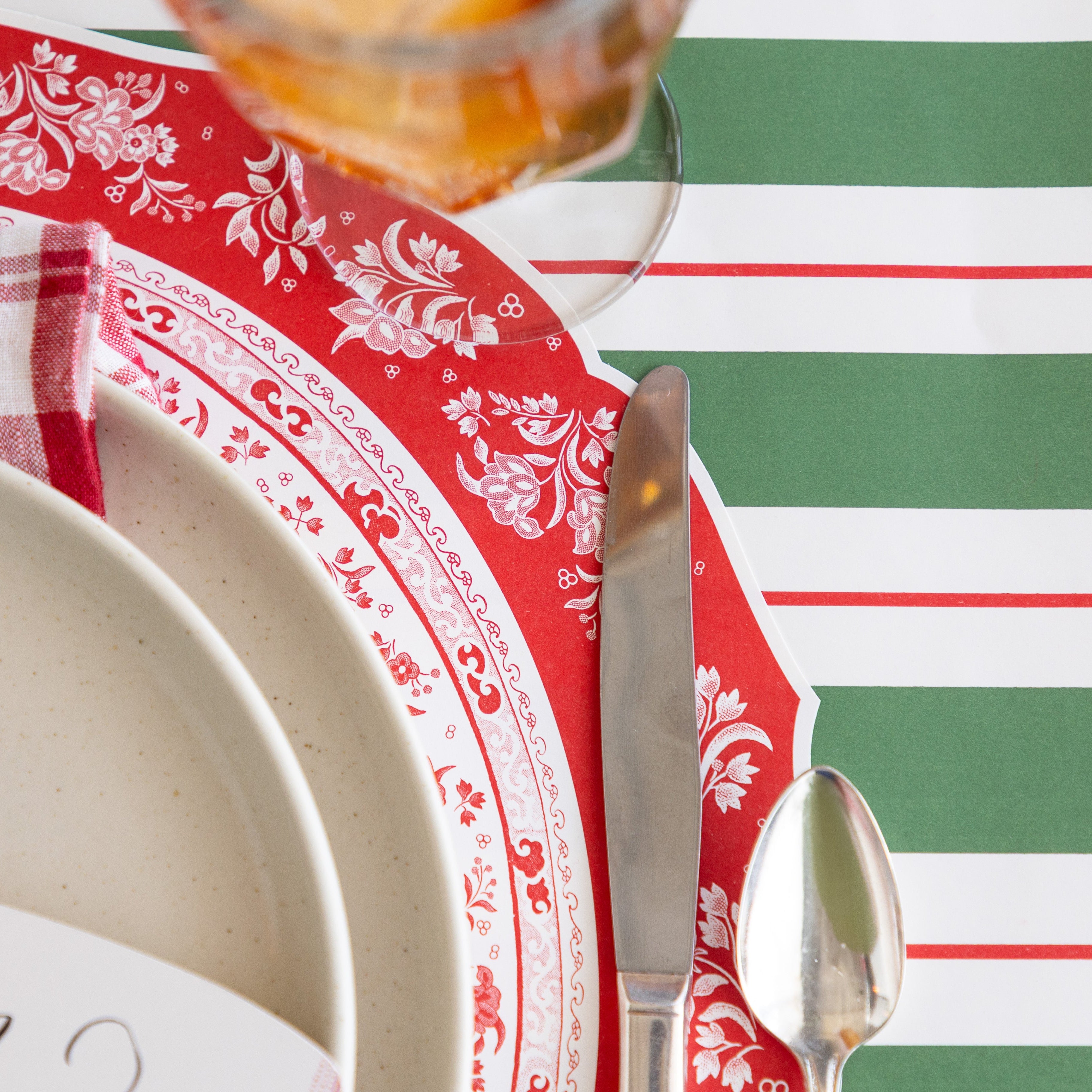 The Die-cut Red Regal Placemat under an elegant place setting with the Green & Red Awning Stripe Runner underneath.