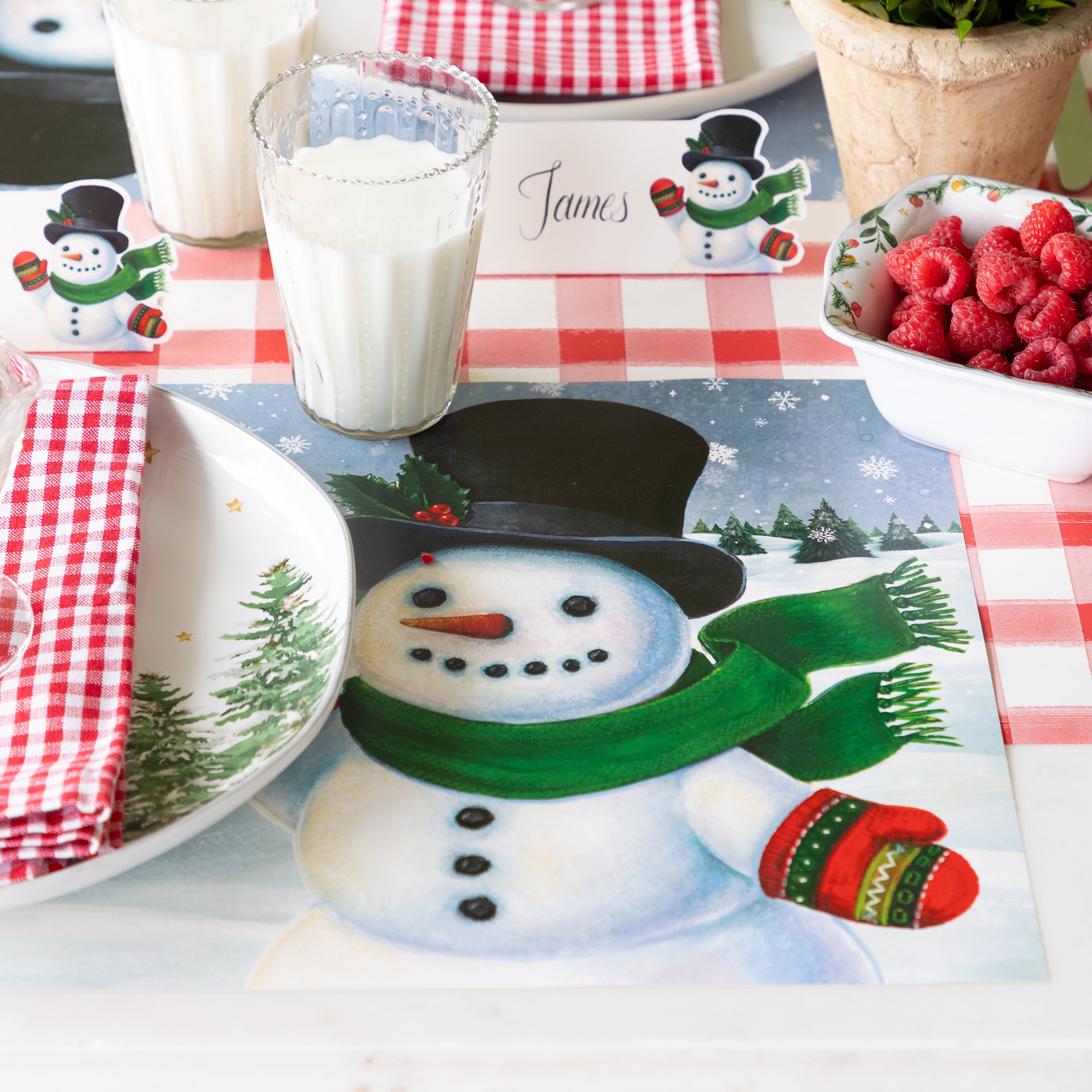 A place setting with the Jolly Snowman Placemat on the Red Painted Check Runner.