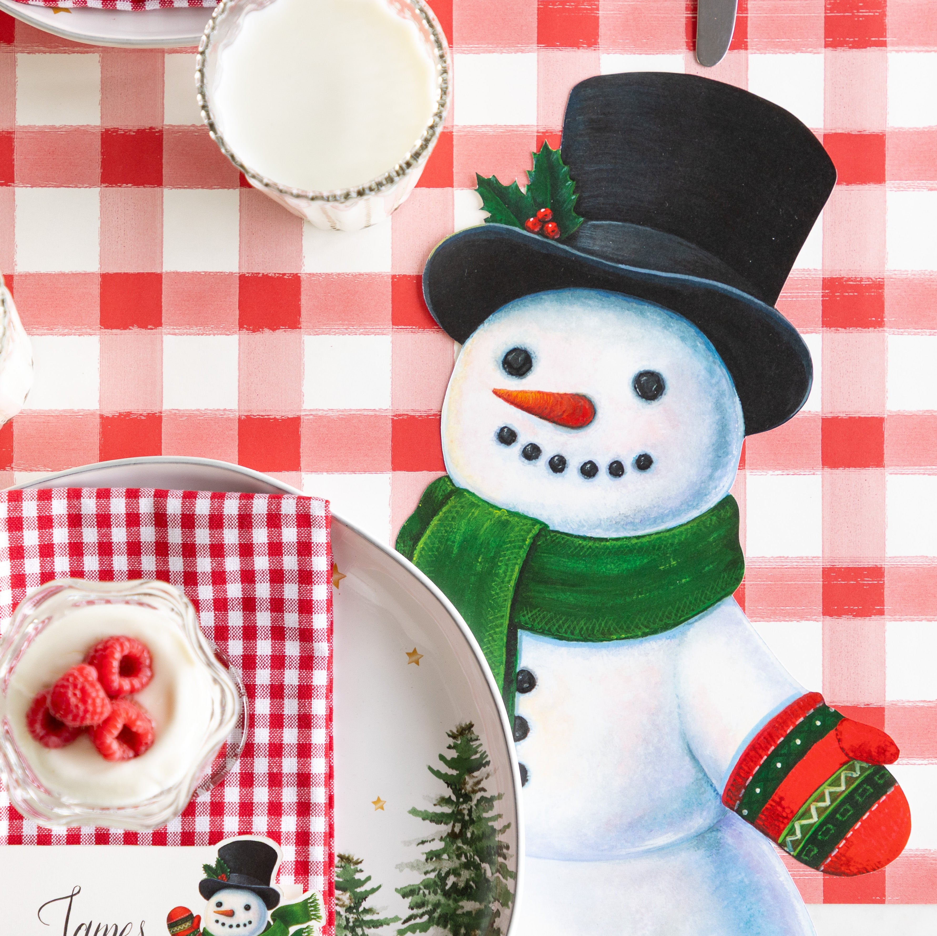 A festive table setting with the Die-cut Jolly Snowman Placemat on the Red Painted Check Runner.