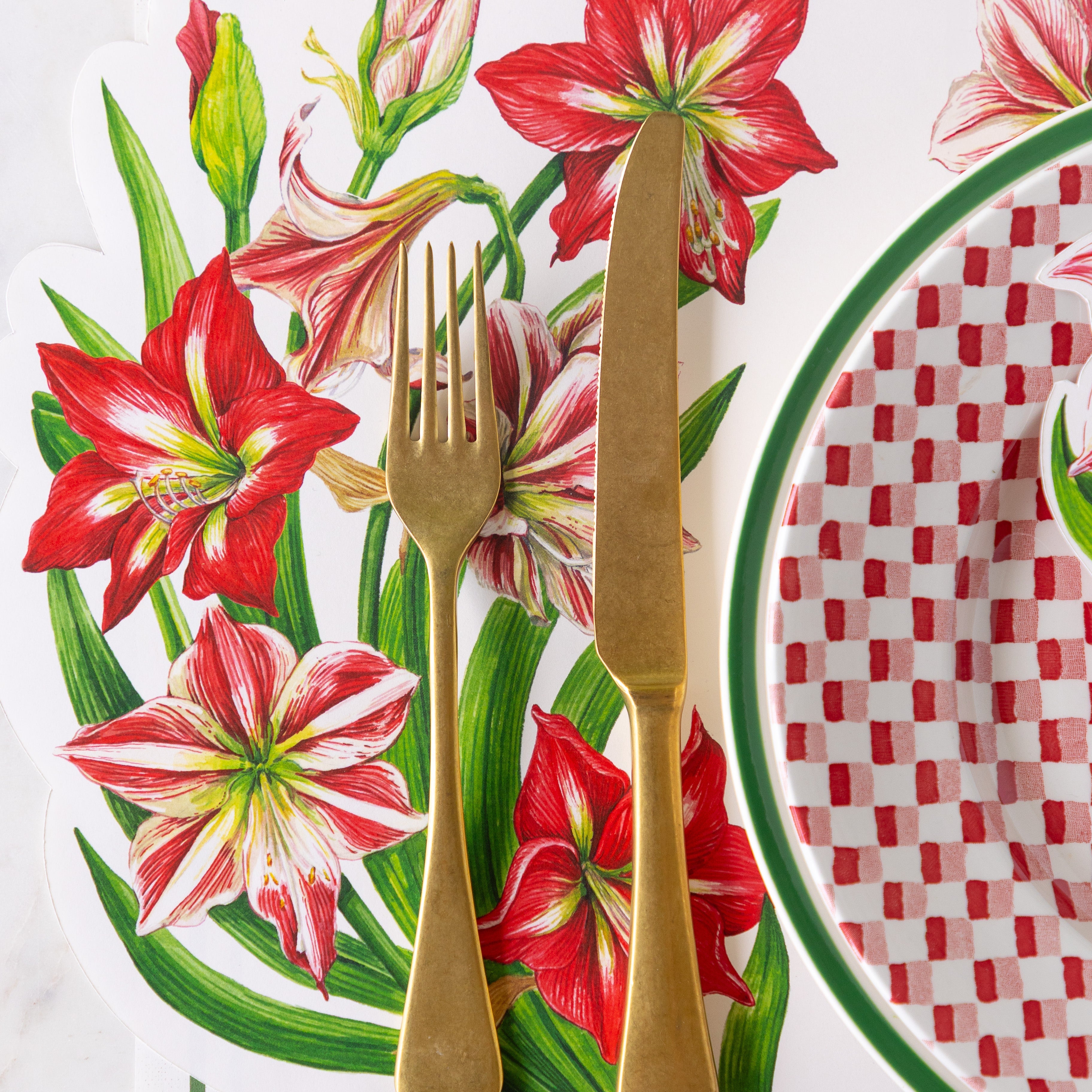 A place setting featuring gold flatware on the Die-cut Amaryllis Placemat.