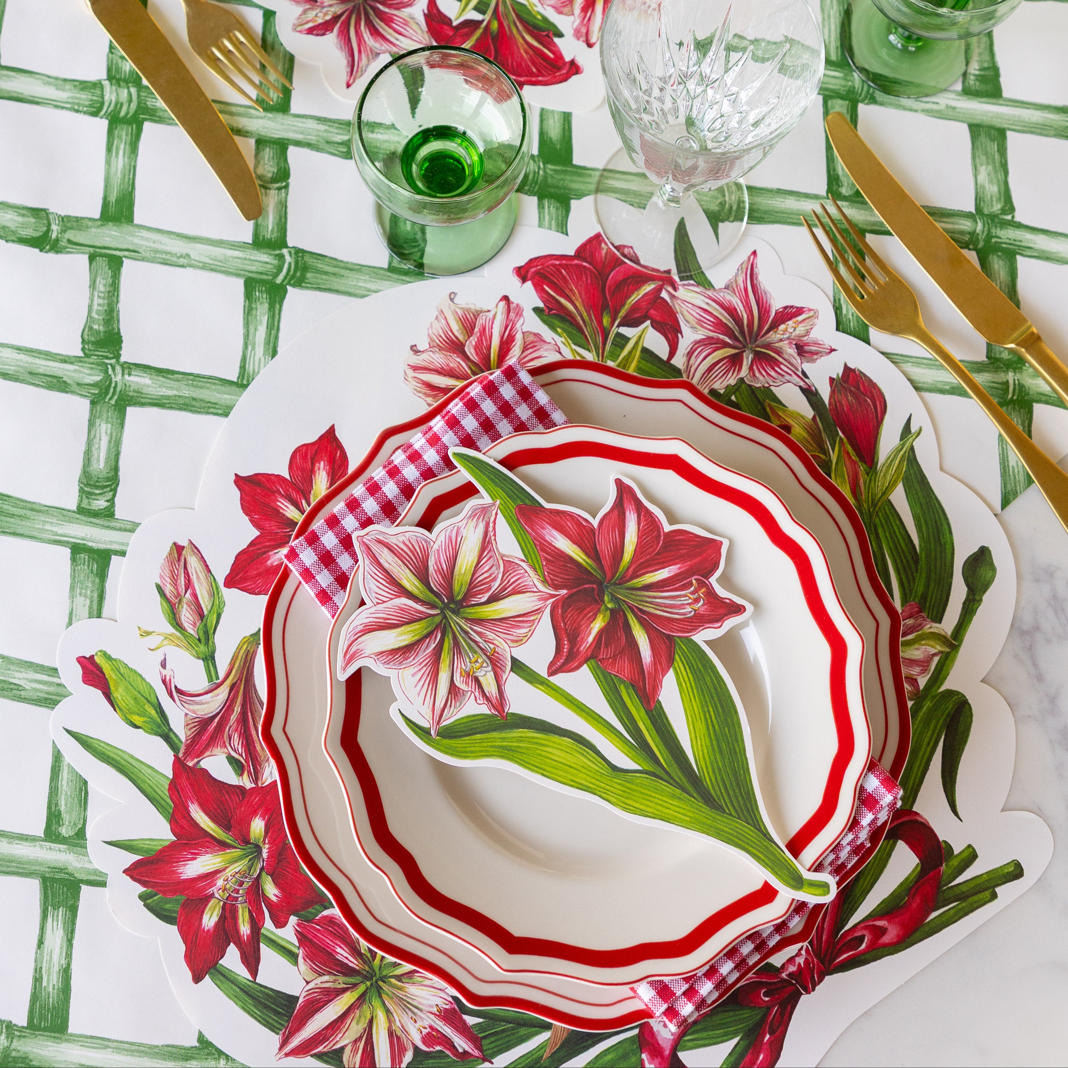 Decorative table setting with the Die-cut Amaryllis Placemat, Red Icing on the Cake plates with the Amaryllis Table Accent atop, and gold flatware on the Green Lattice Runner.