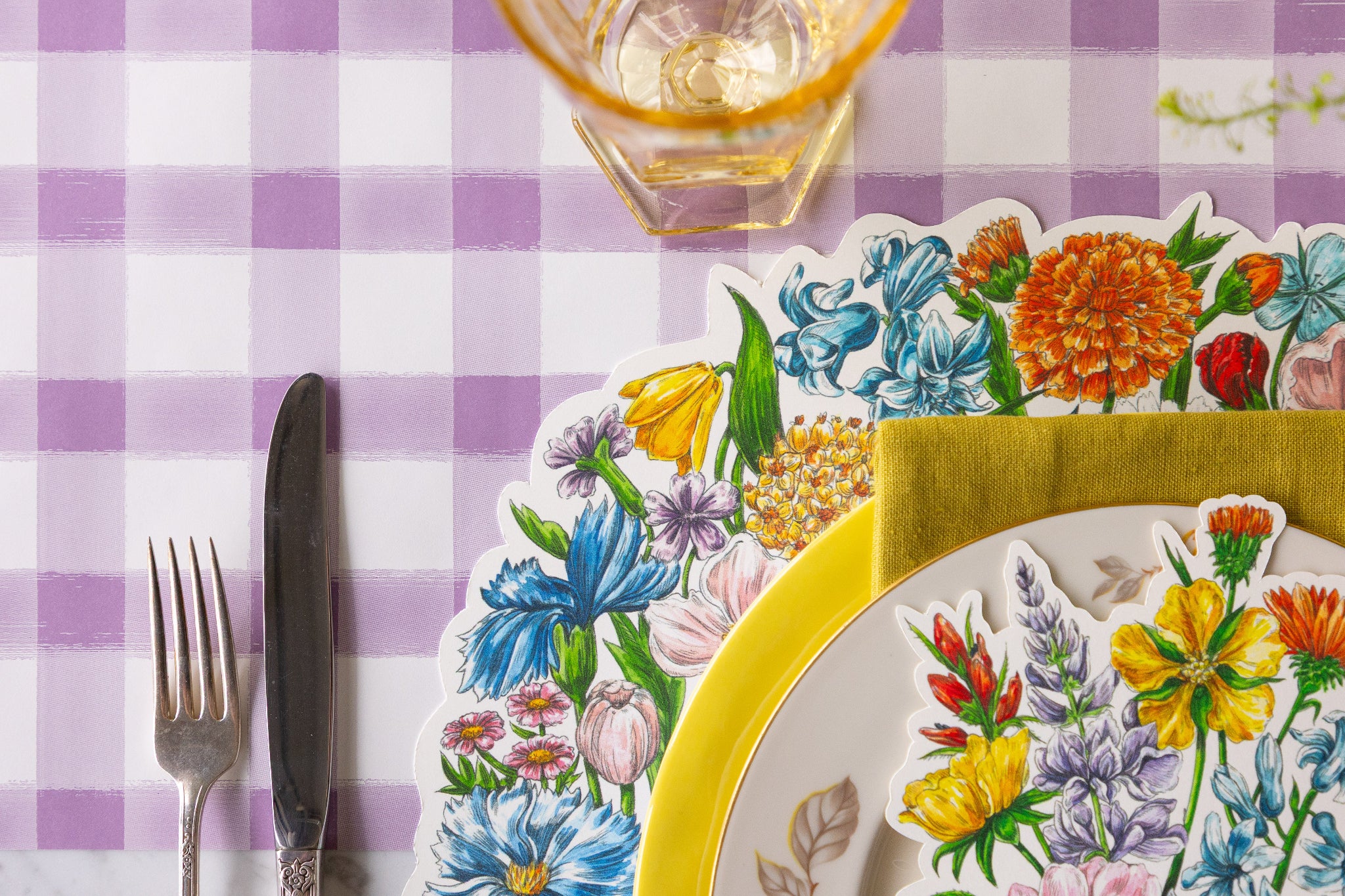 Table setting with Die-cut Wildflower Wreath Placemat, Wildflower Table Accent and colorful plates on the Lilac Painted Check Runner.