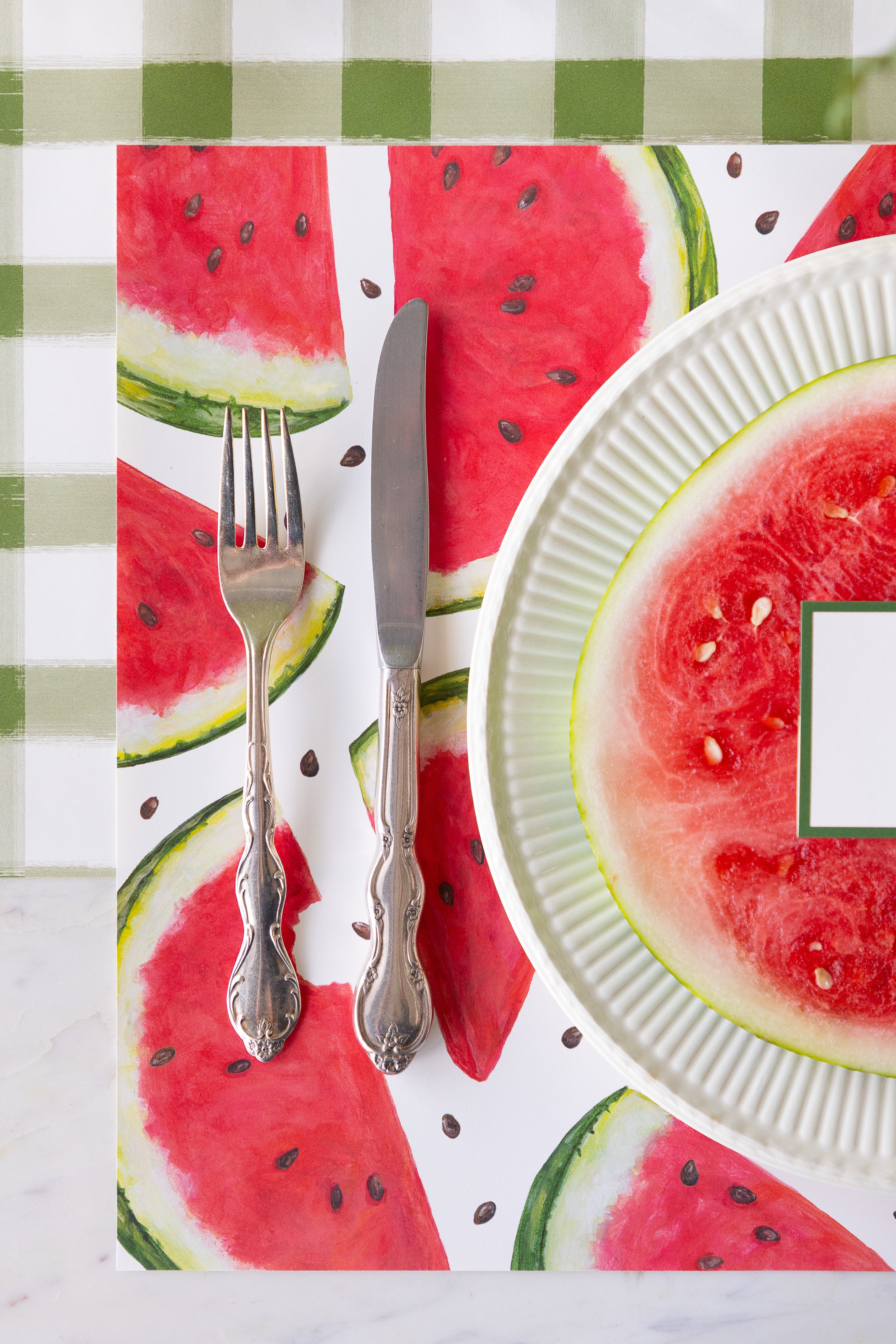Placemat with watermelon design featuring a fork, knife, and plate.