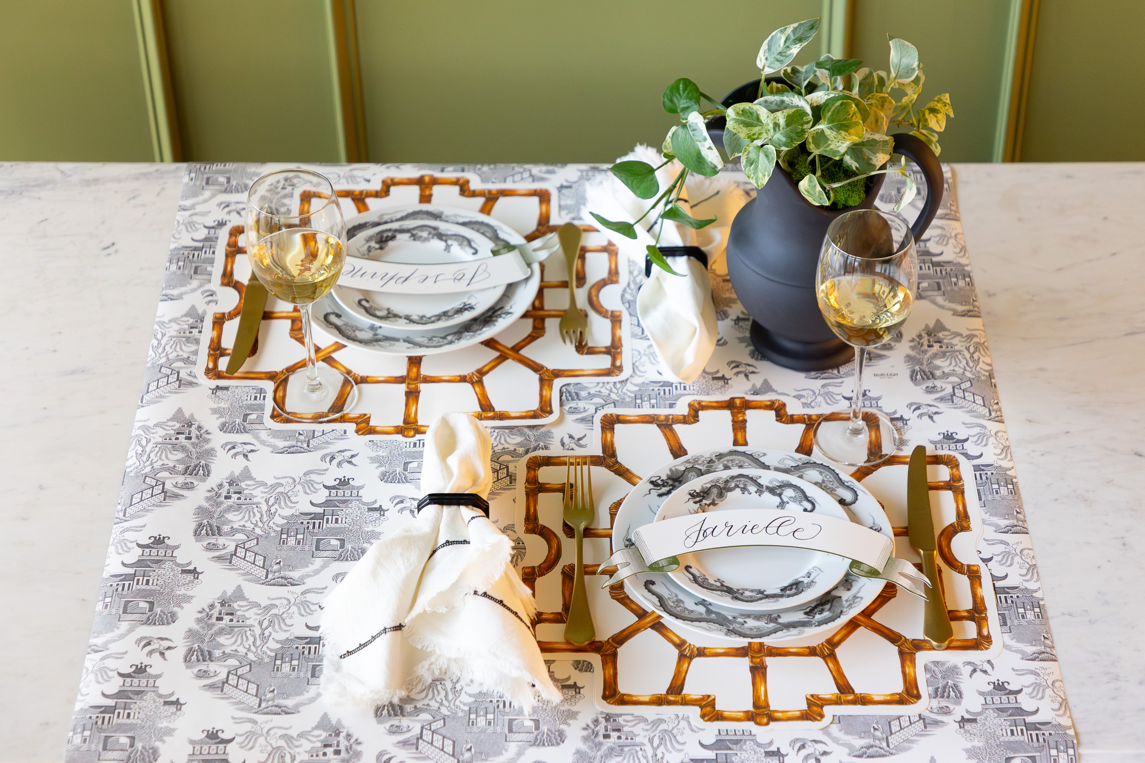 Table set with a vase of flowers, Die-cut Bamboo Placemats, Black Icing on the Cake plates, Classic Moss Banner Table Accents and vintage flatware on the Black Willow Runner.