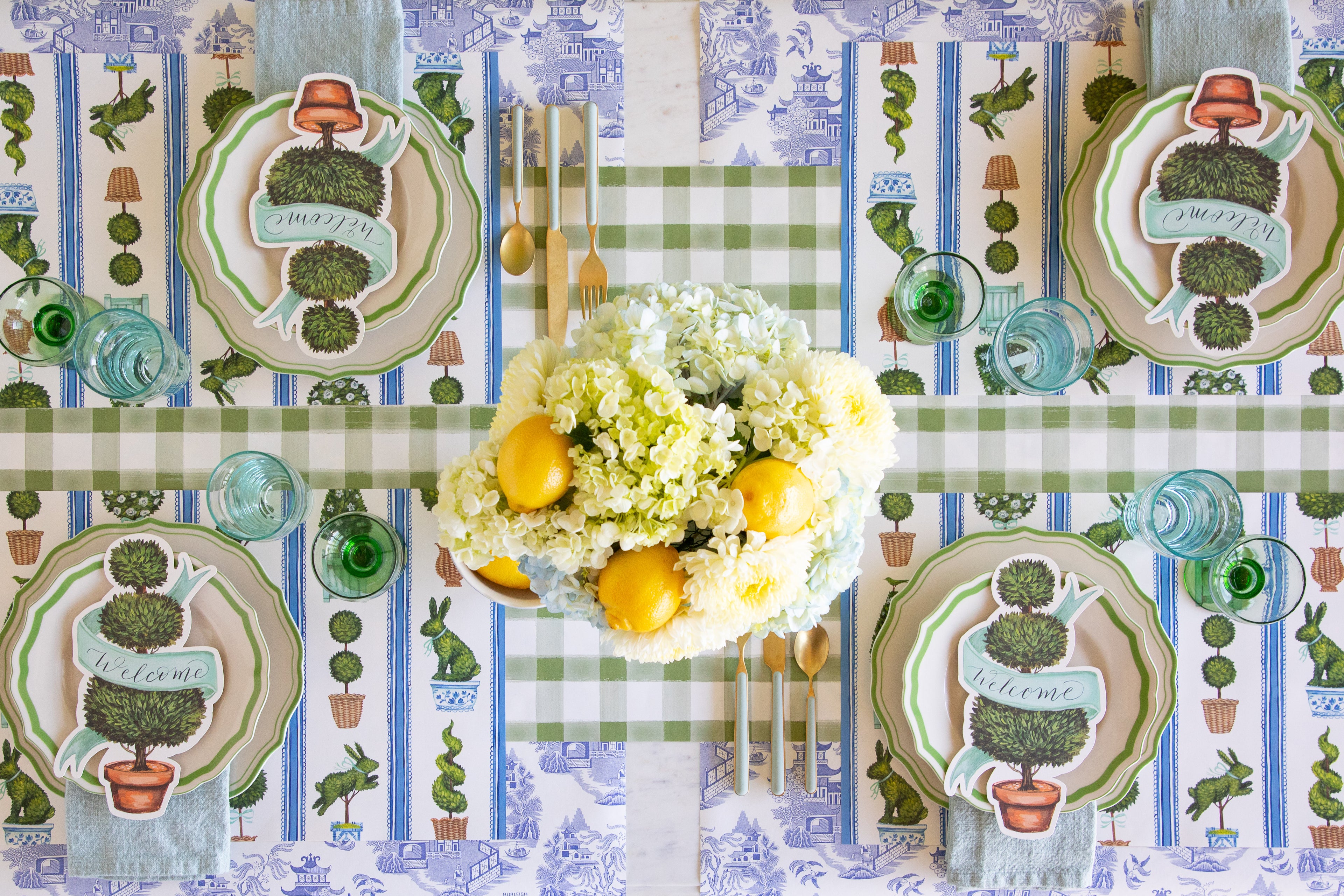 Decorative table setting with floral arrangement and plates on a patterned tablecloth.