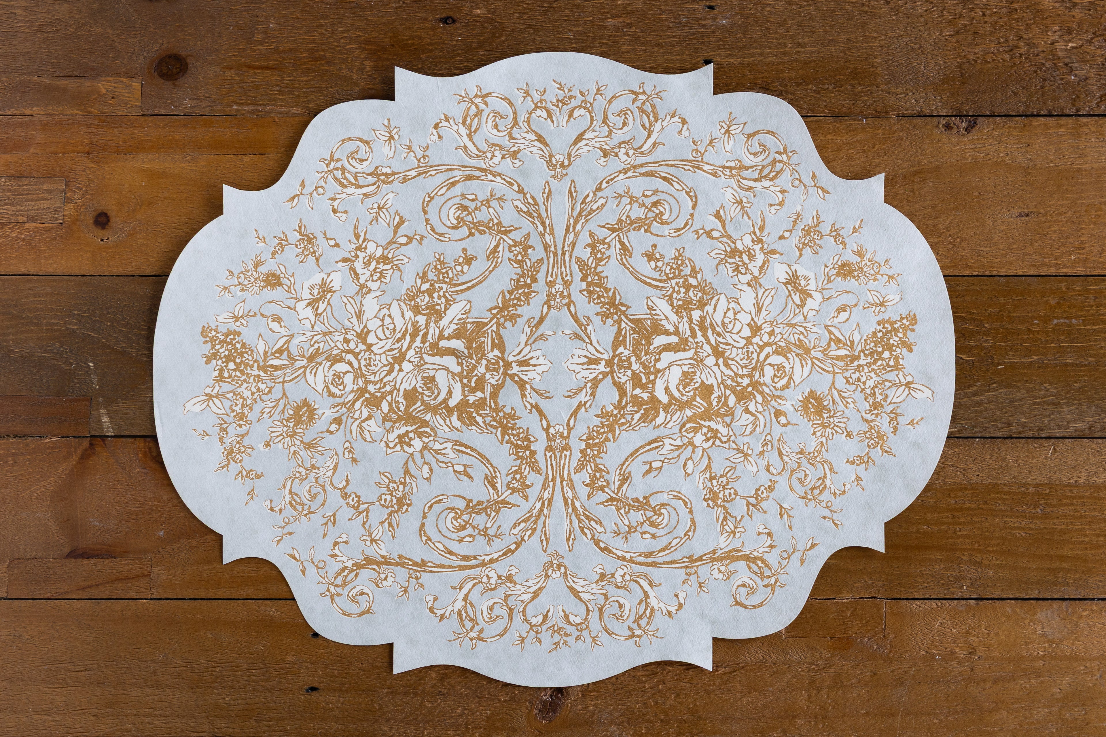 Die-Cut Gilded Scroll Frame Placemat on a wood background.